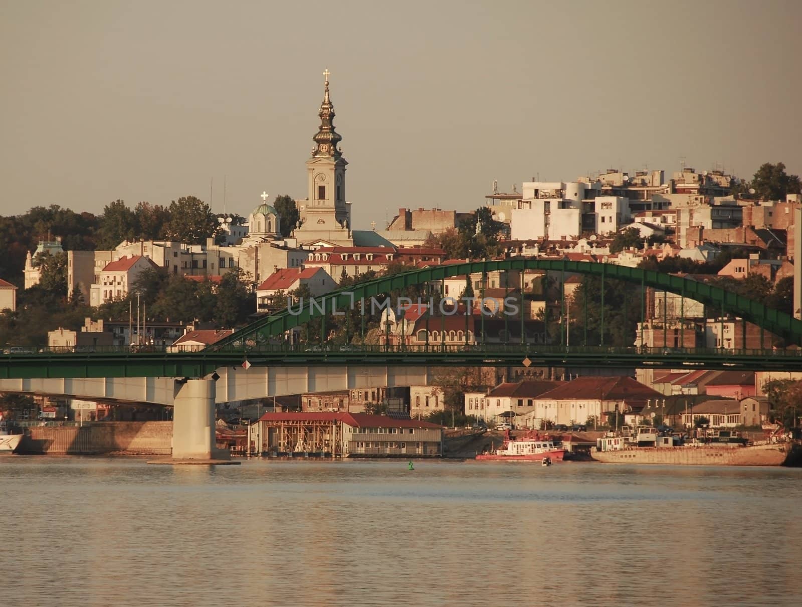 Belgrade cityscape in Serbia, bridge and buildings over water gray toned