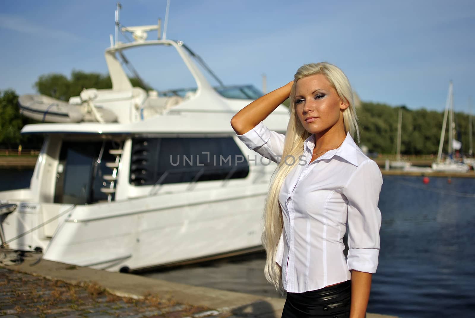 portrait of blonde girl in a white shirt against the boat