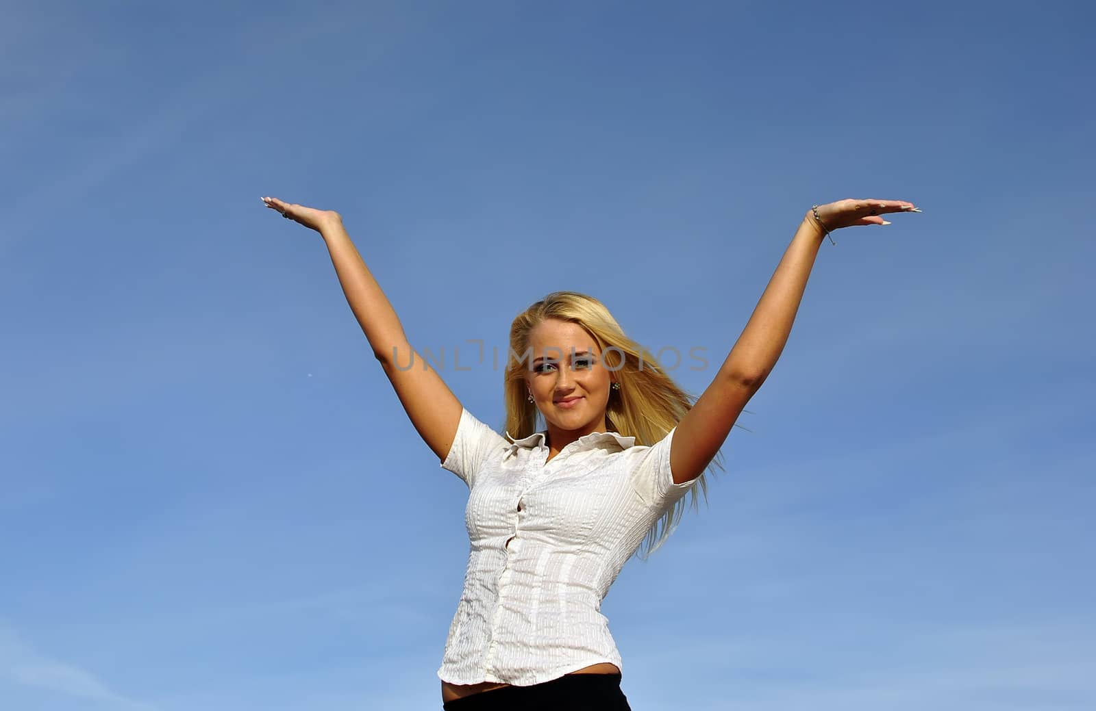 Blonde girl in a white shirt against the sky. Ideally suited for advertising. Space for text