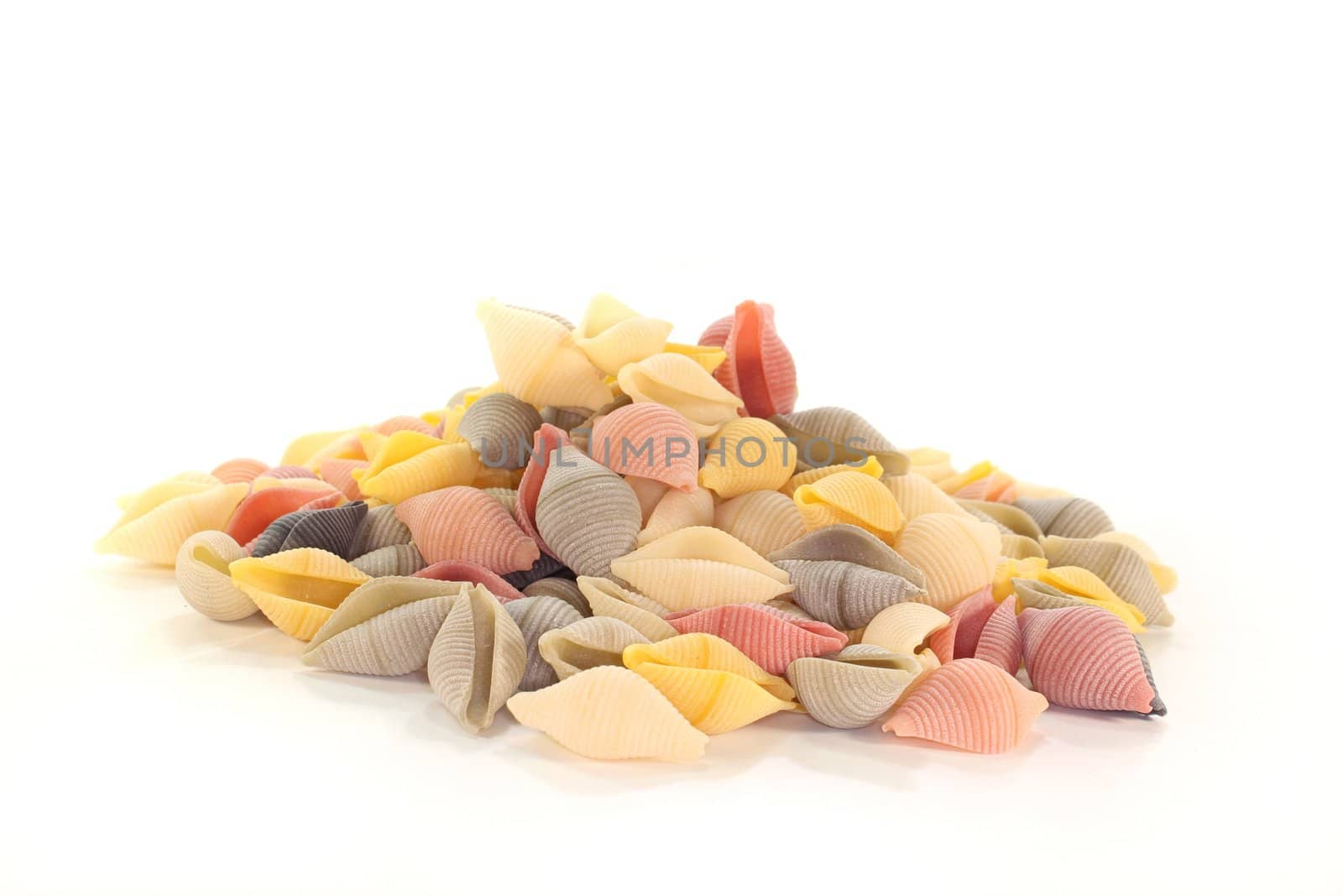 a handful of colored pasta on white background
