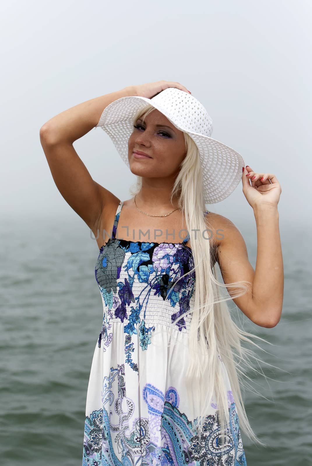 Girl in hat standing in the misty sea