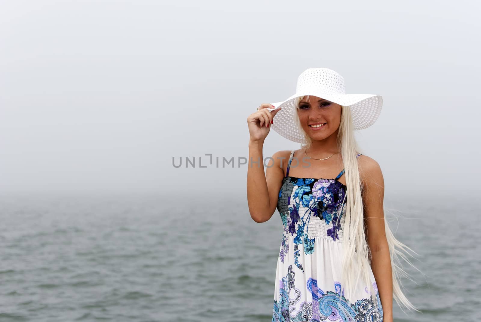 Girl in hat standing in the misty sea
