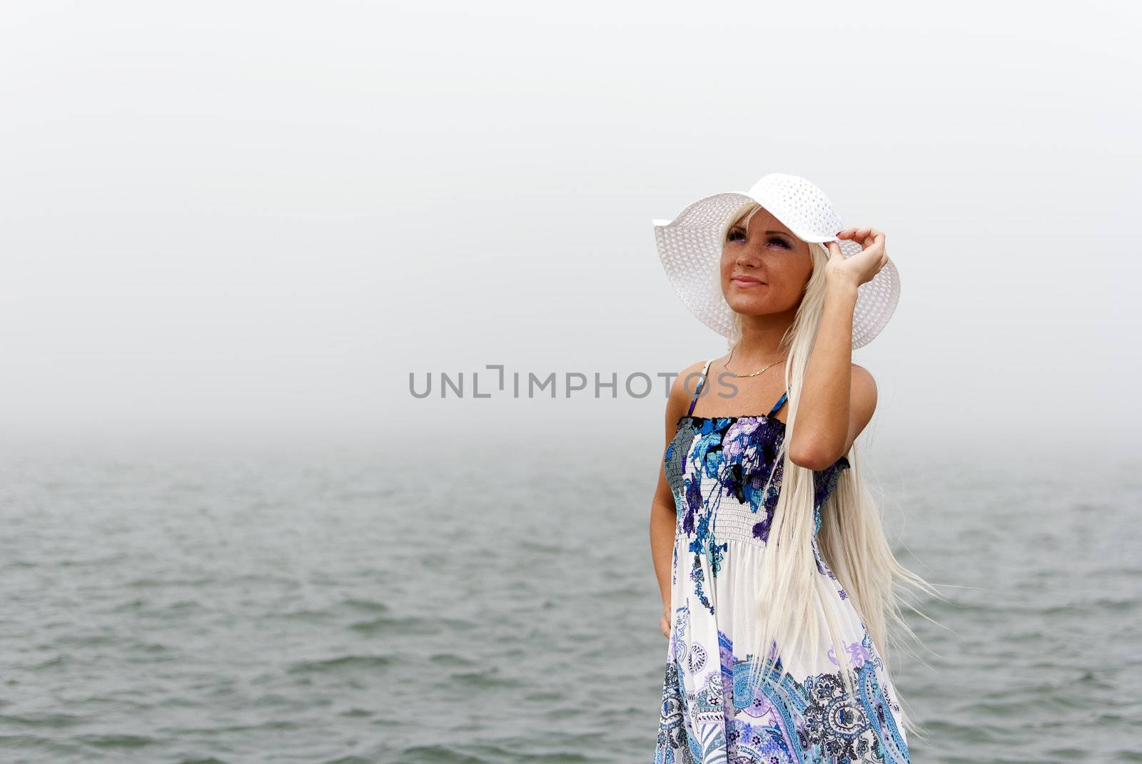 Girl in hat standing in the misty sea
