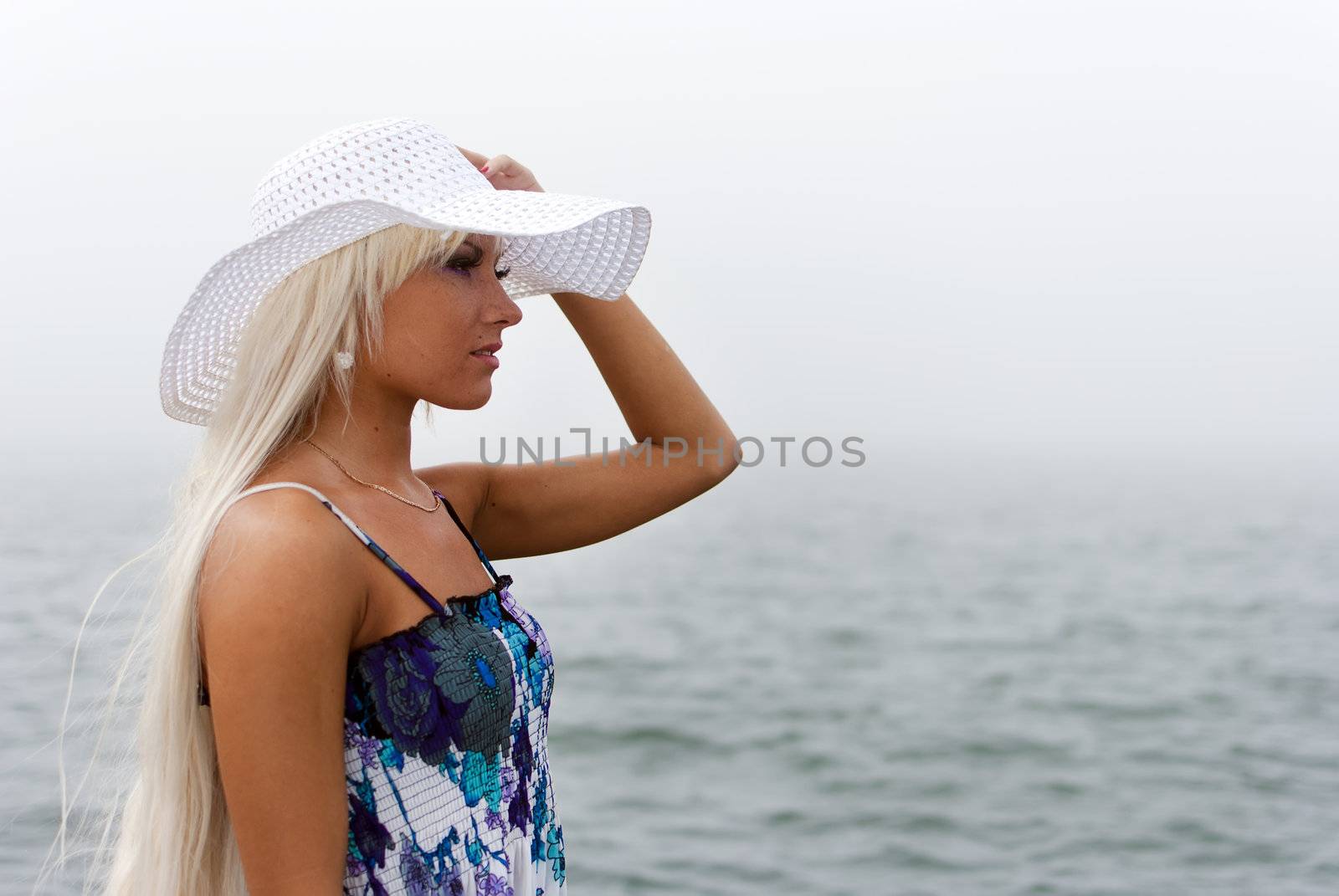 Girl in hat standing in the misty sea