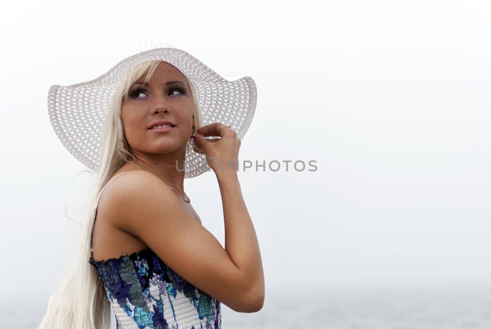 Girl in hat standing in the misty sea