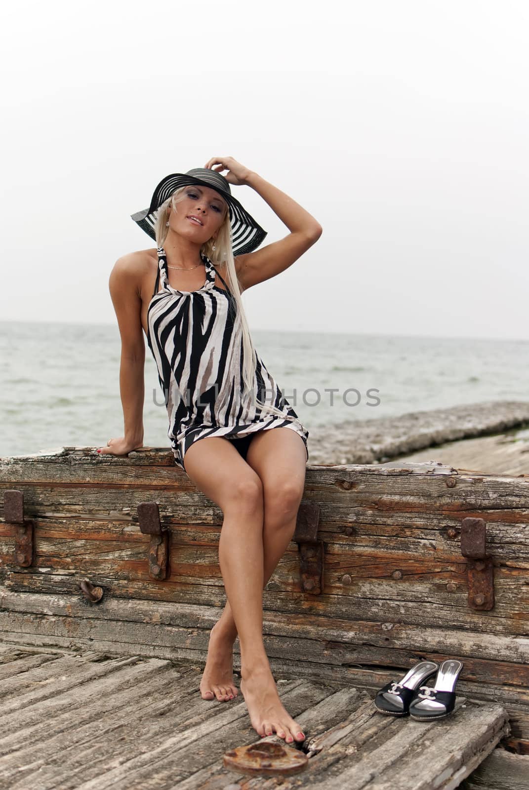 girl in a hat sitting on a broken ship at sea