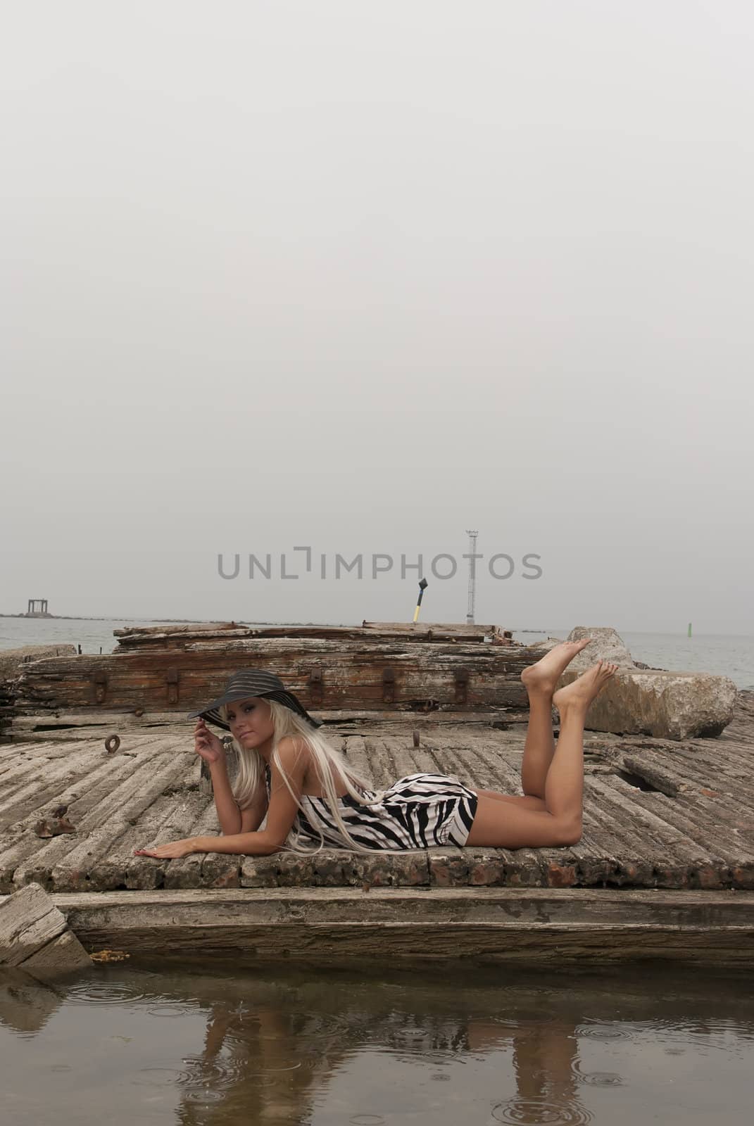 girl in a hat lying on a broken ship at sea