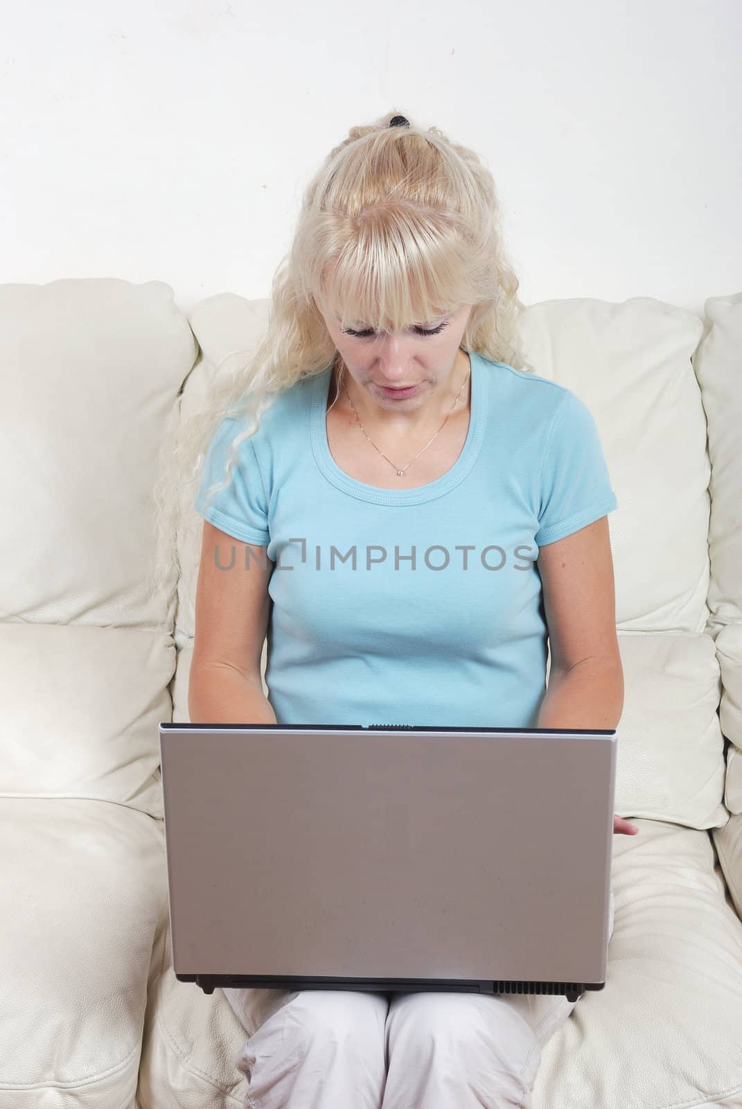 portrait of blond woman on sofa with notebook computer