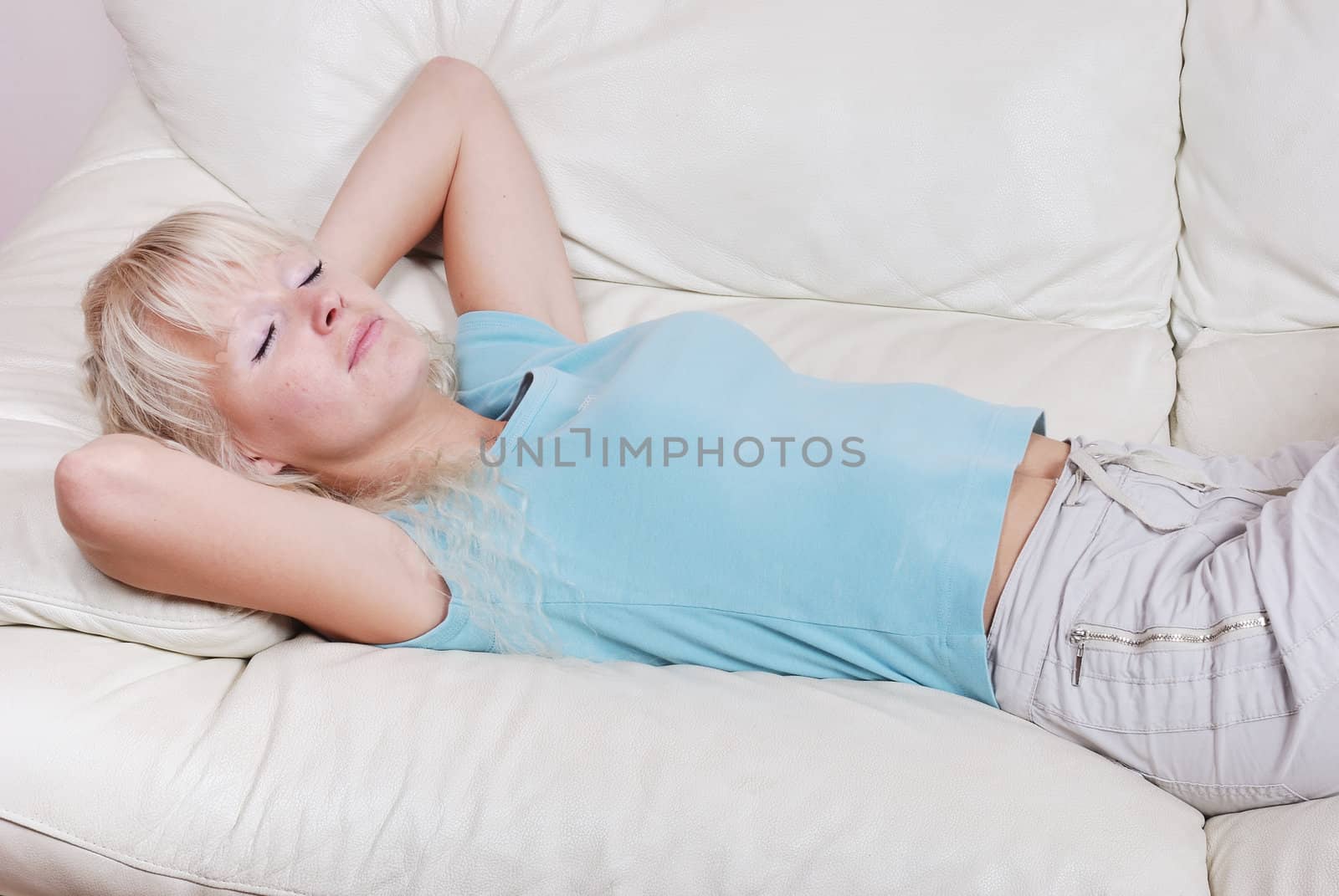 Blond woman resting  on a sofa