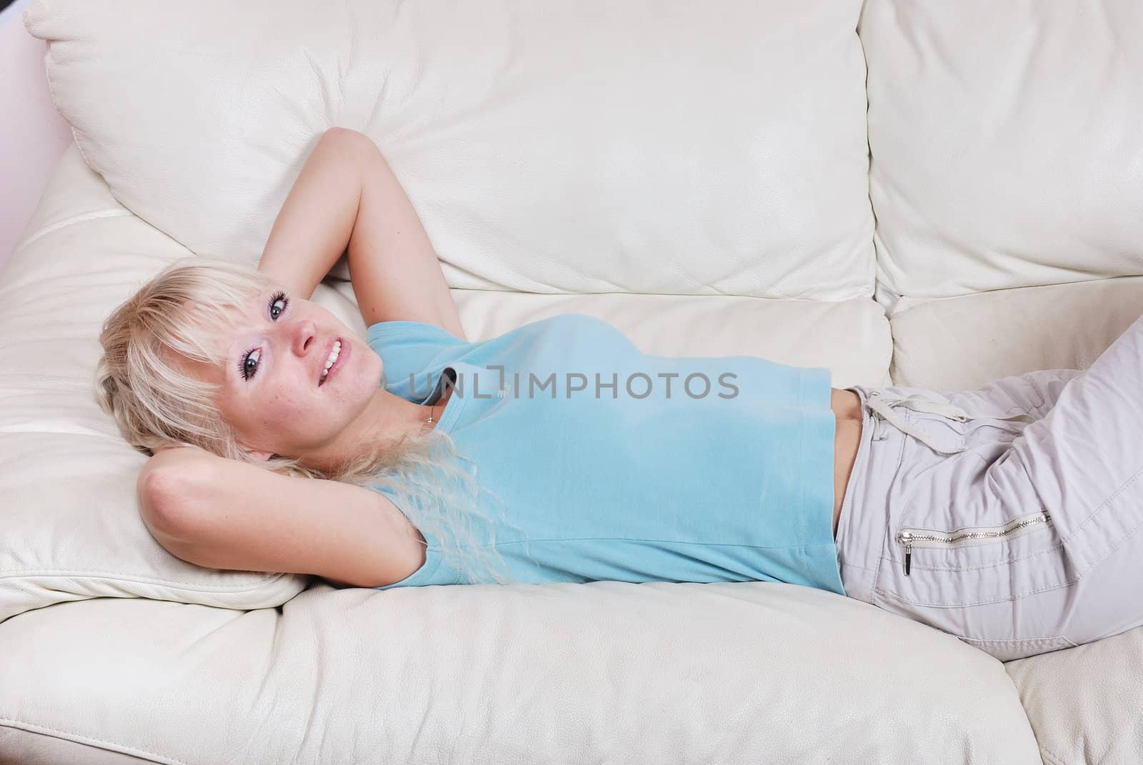 Blond woman resting  on a sofa
