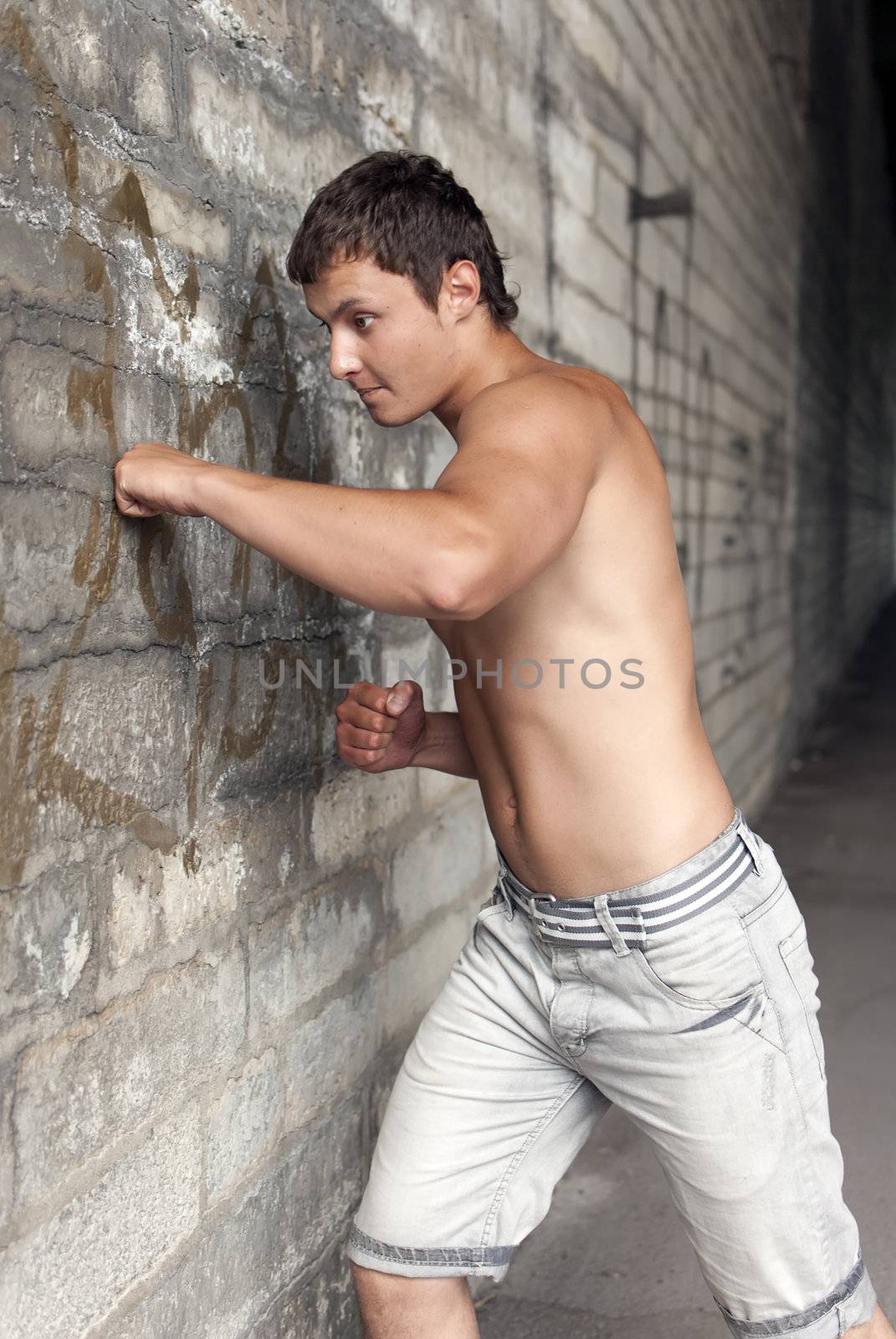 muscular guy hits the wall on the street