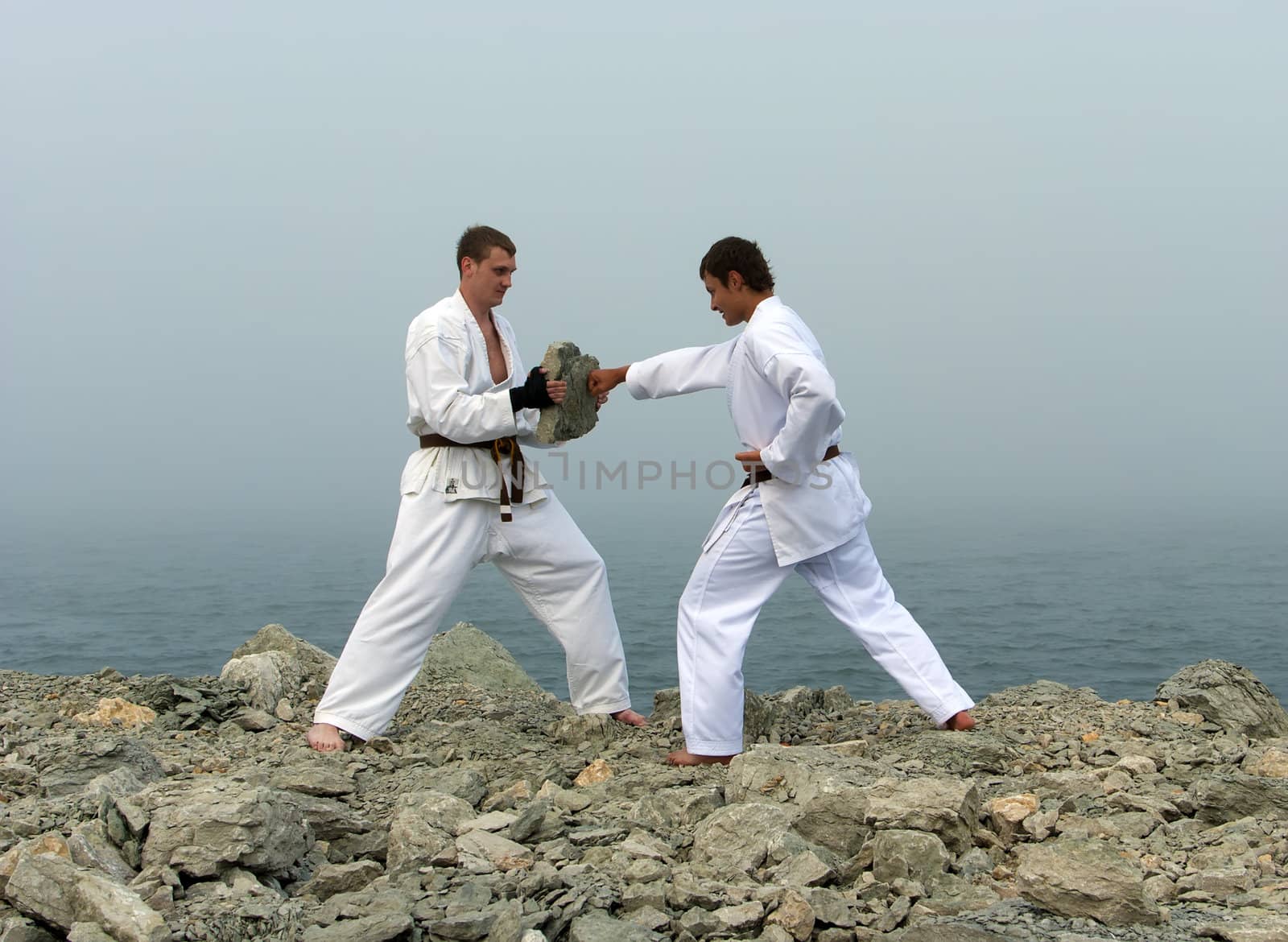 two karateka fight on the banks of the misty sea