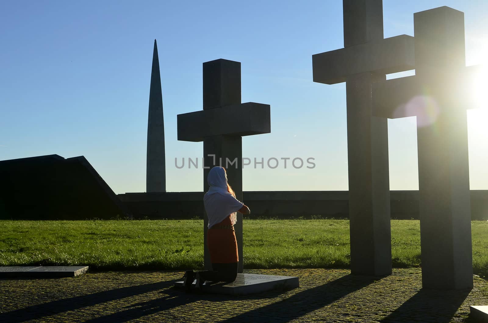 Girl praying at the Crosses at sunset