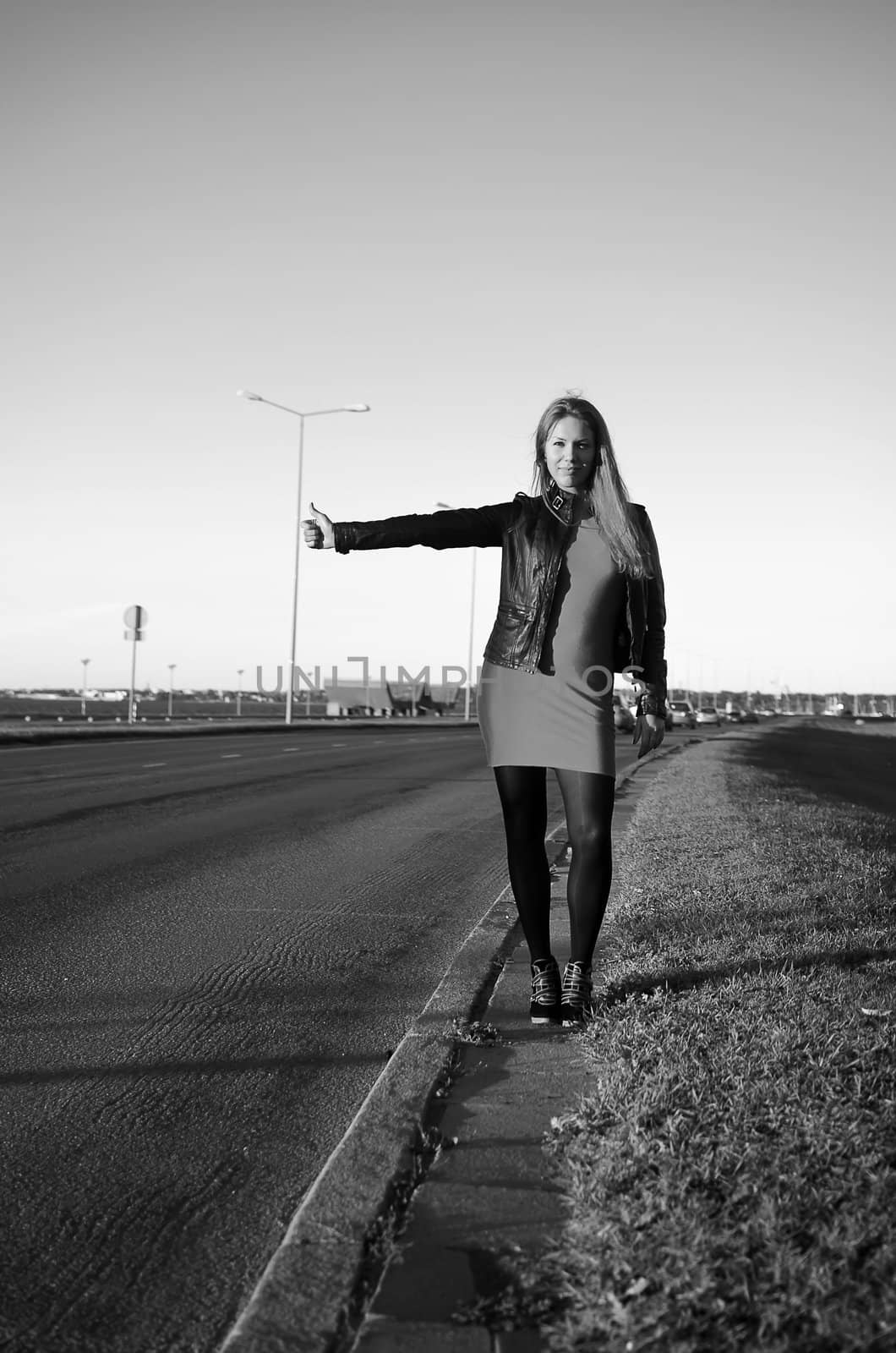 girl on the road waiting for a car, black and white photo