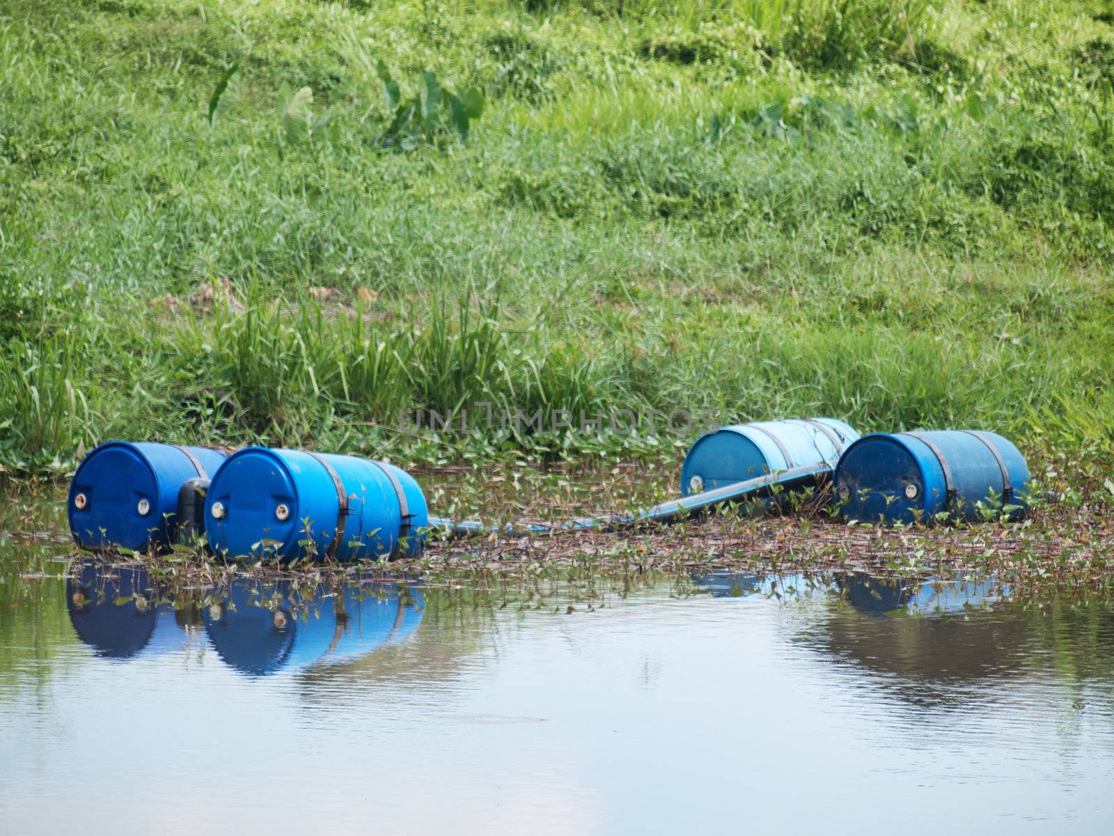 Two blue drums filled with chemicals in a river