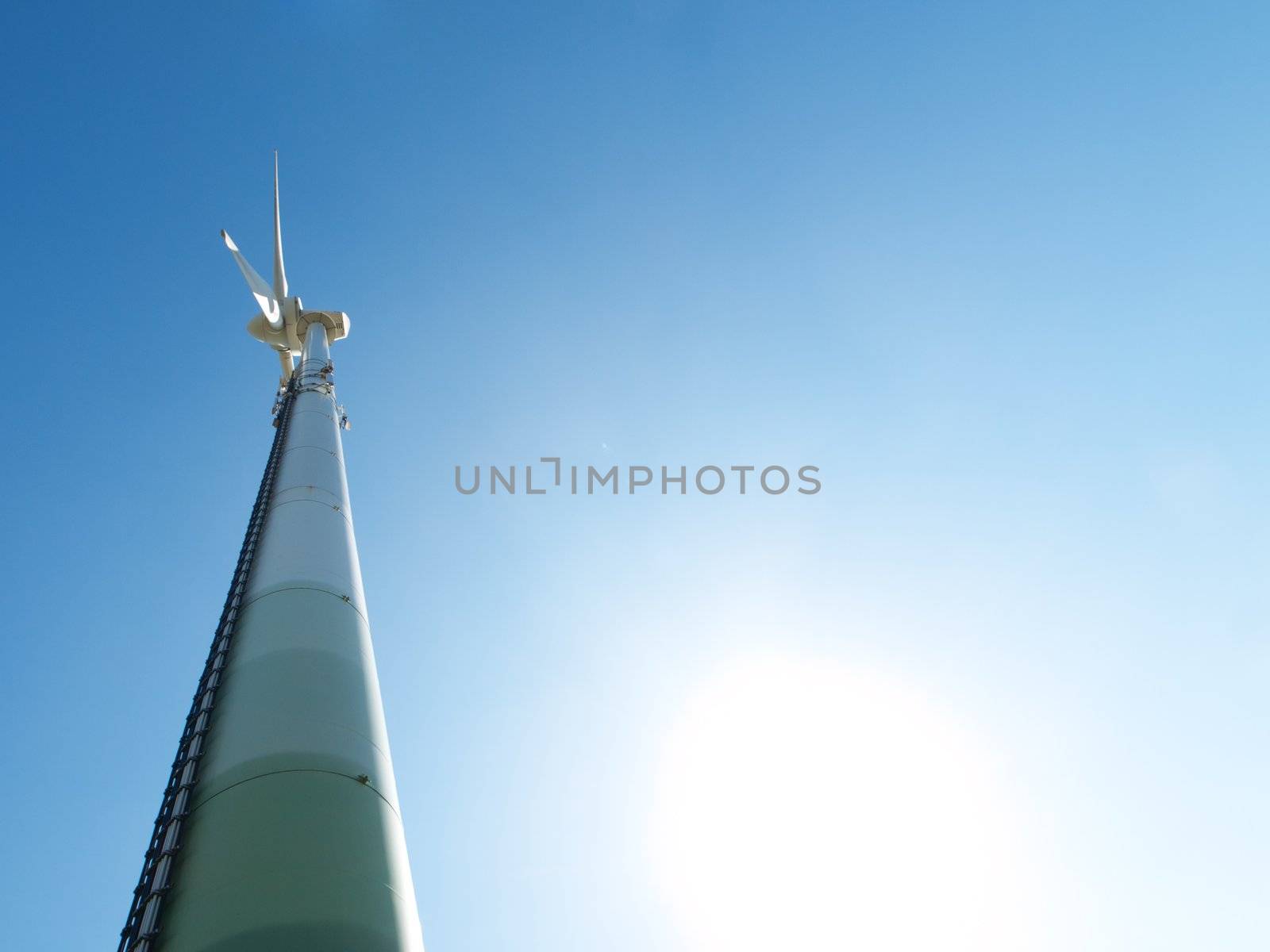 Wind turbine under the sun during  a clear blue sky