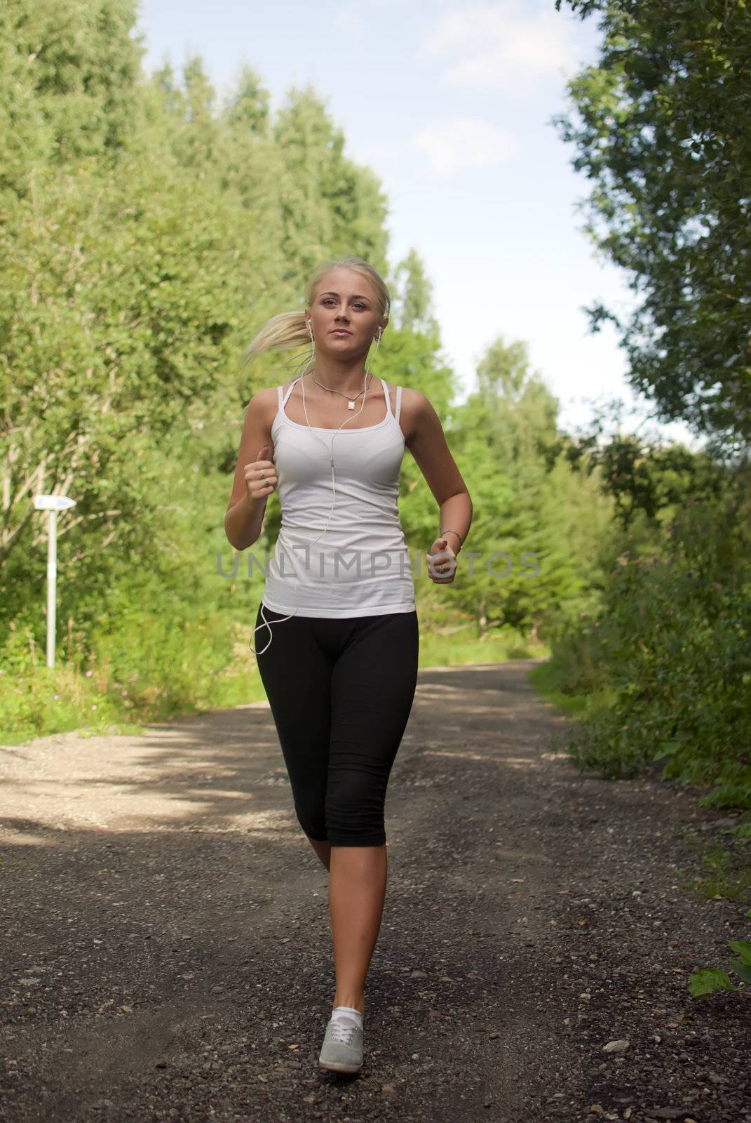 Girl with a music player running on the road