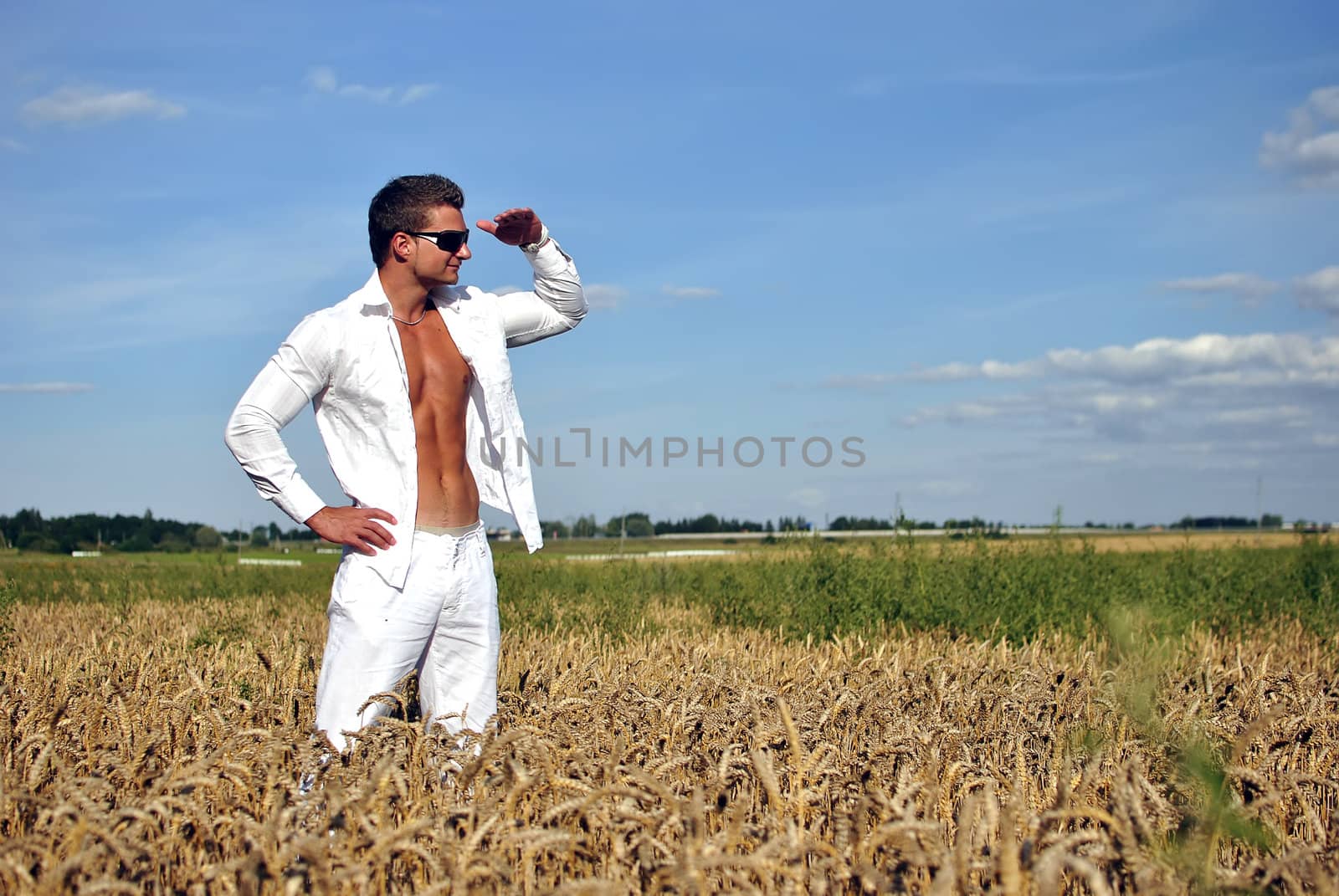 Bodybuilder with sunglasses dressed in white on the field