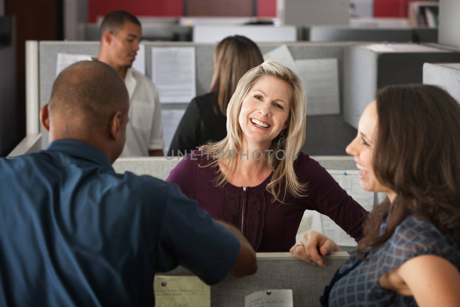 Office workers laugh at a joke shared by colleague