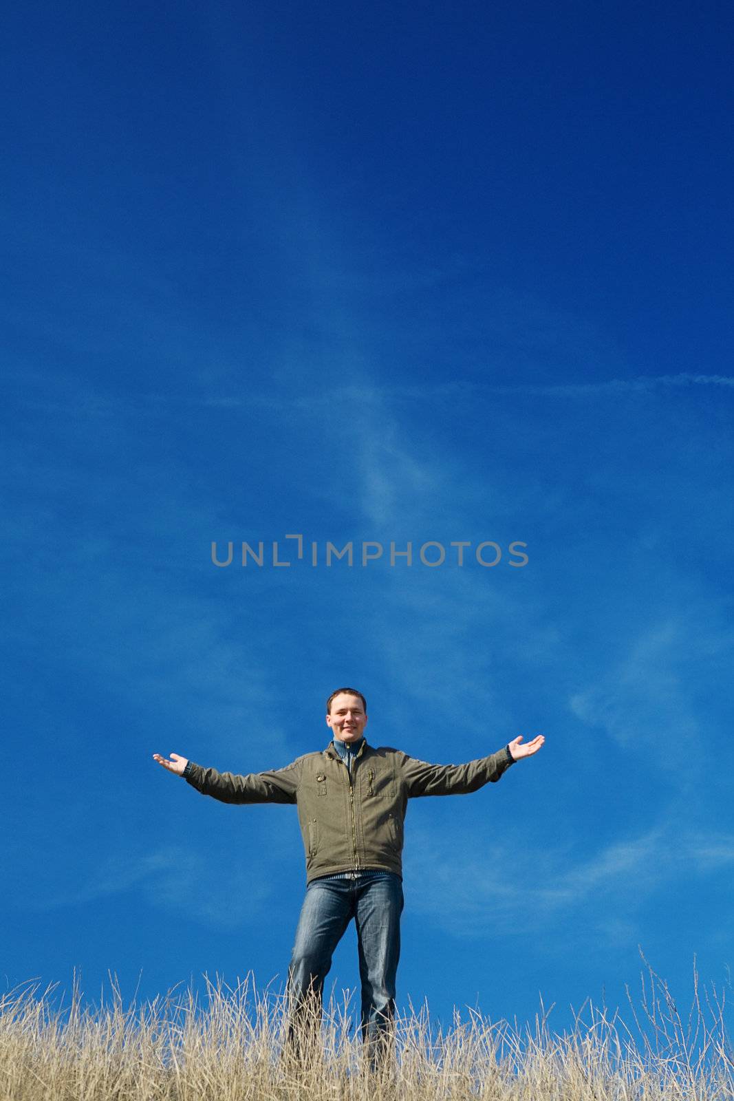 successful and happy man stay on a background of the blue sky