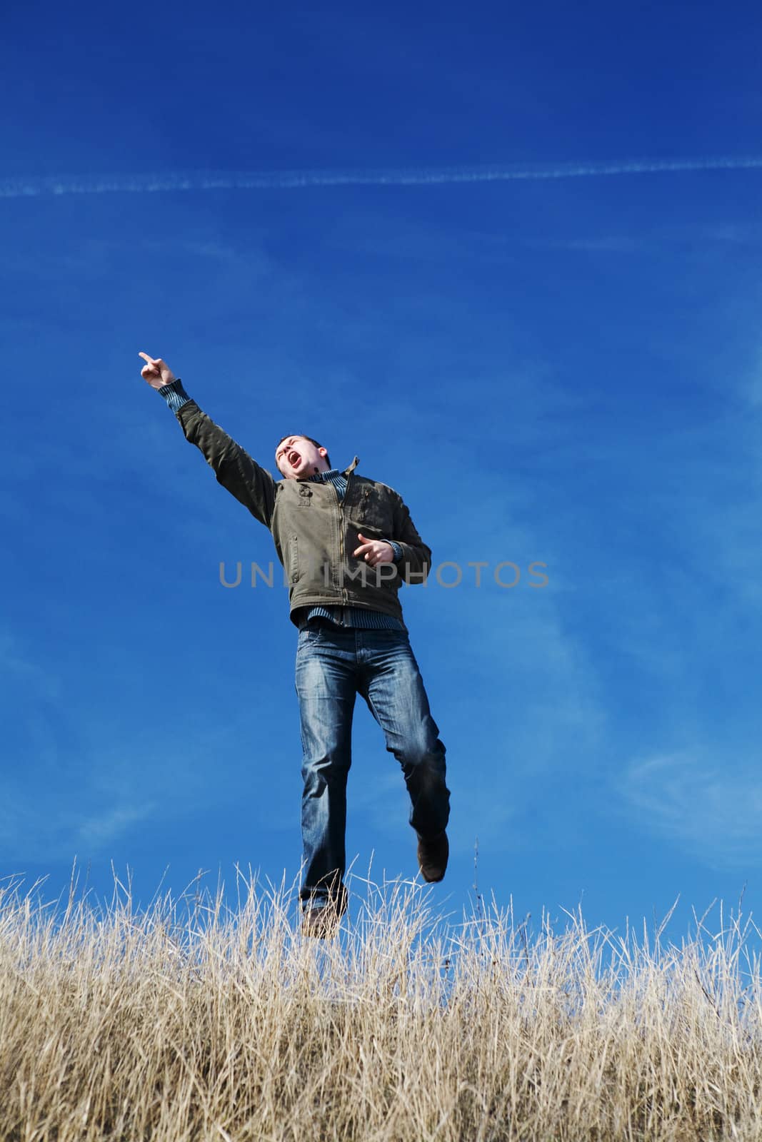 successful and happy man running and jumping in the yellow field