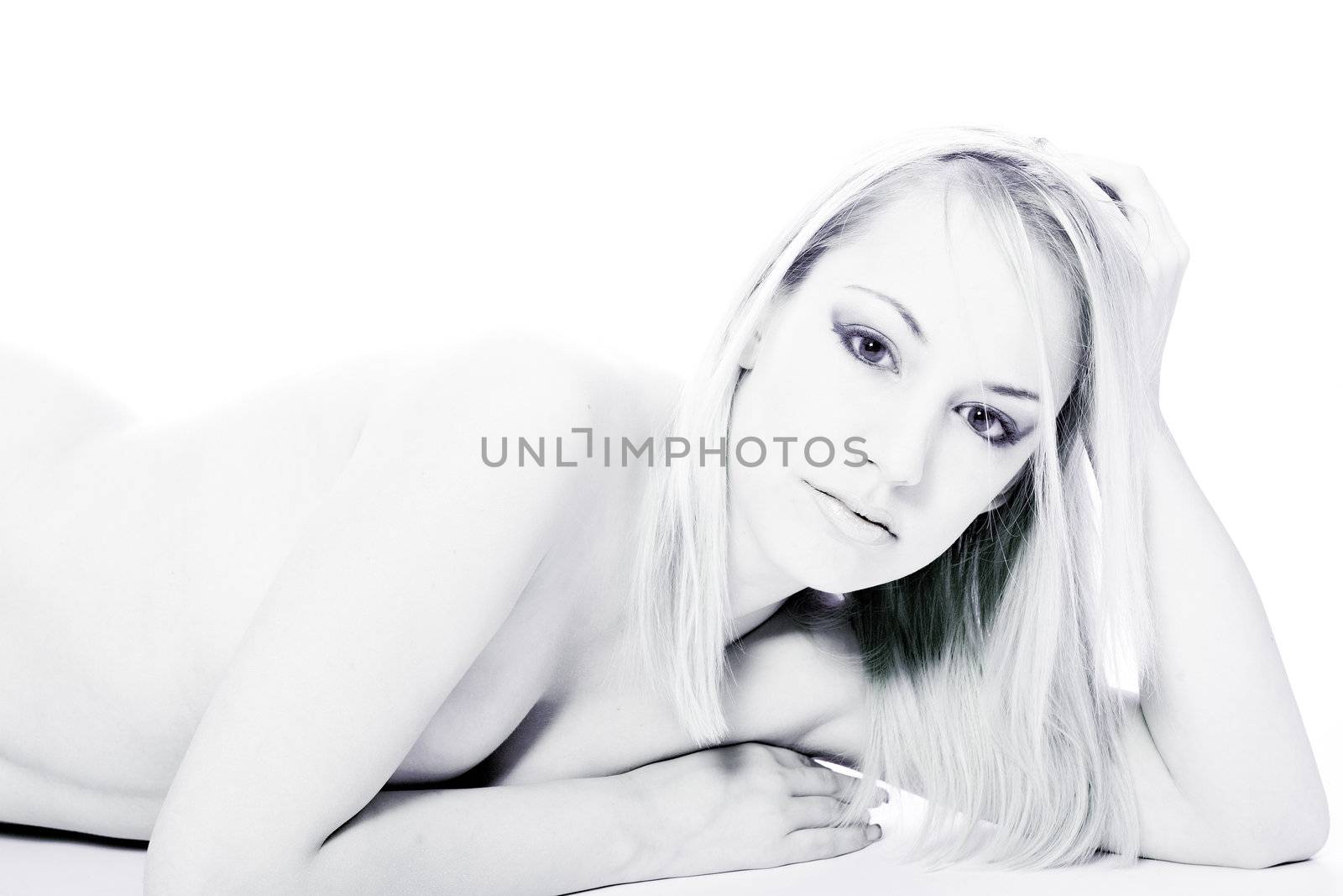 Studio portrait of a young blond woman lying down naked