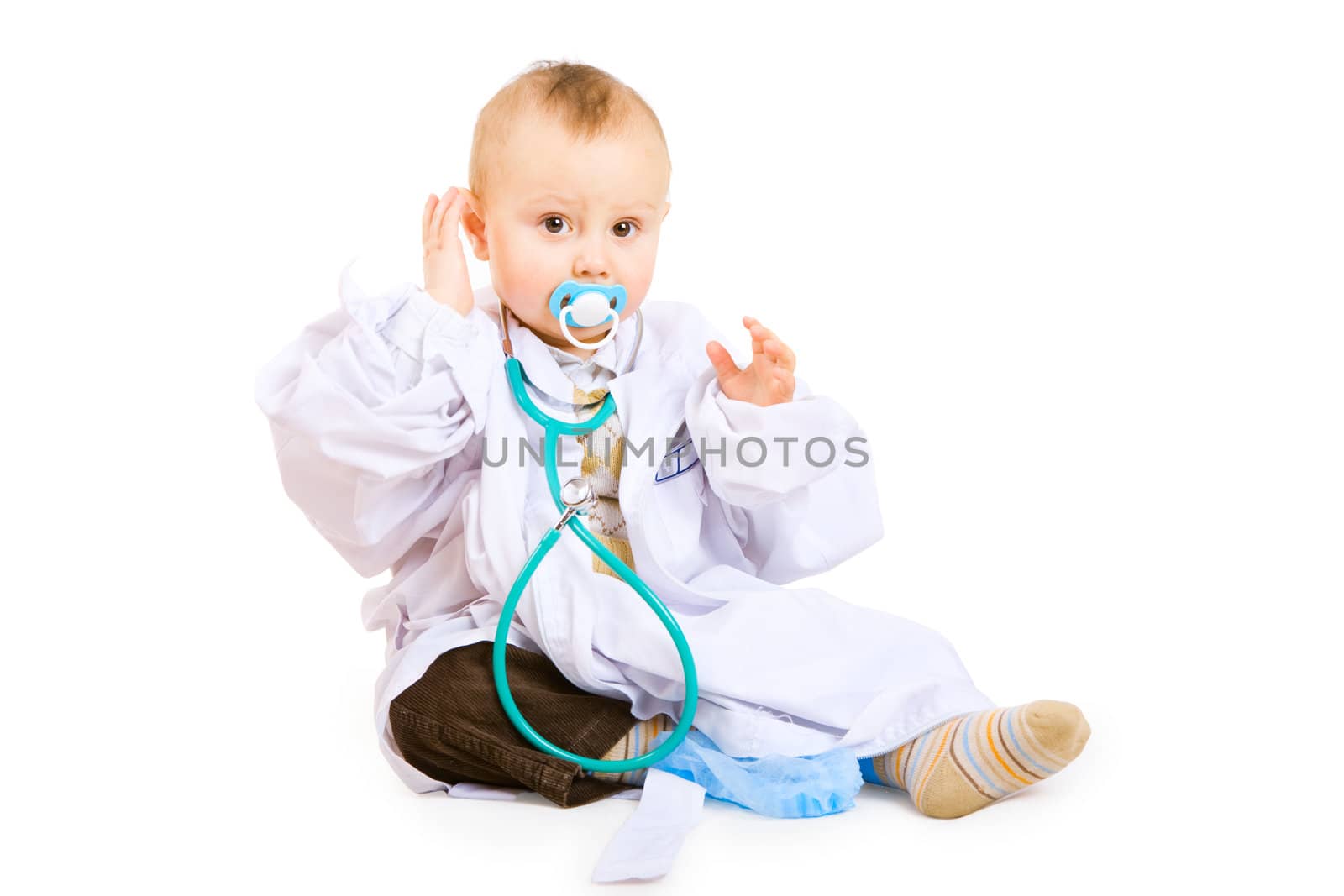 boy of one year old in white gown of doctor with stethoscope