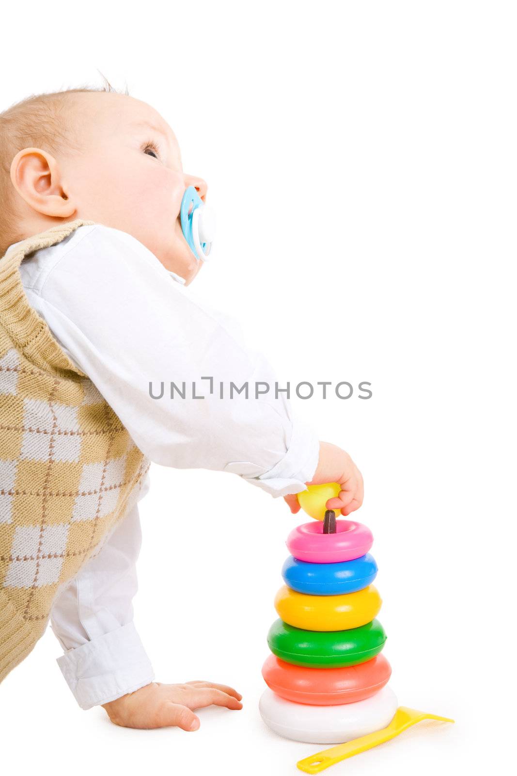 The toddler boy plays developing game. Color pyramidion.