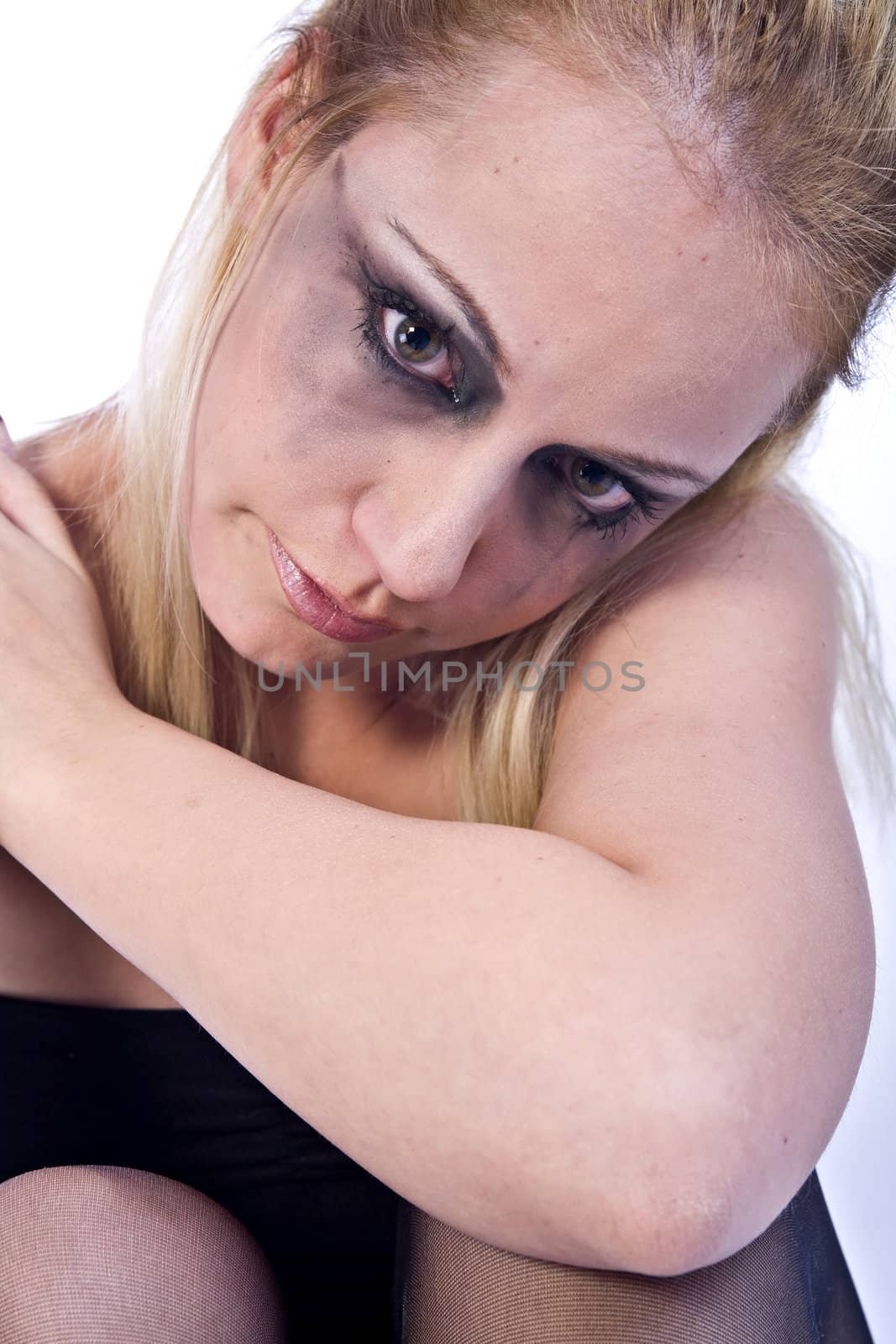 Studio portrait of a young blond woman looking sad