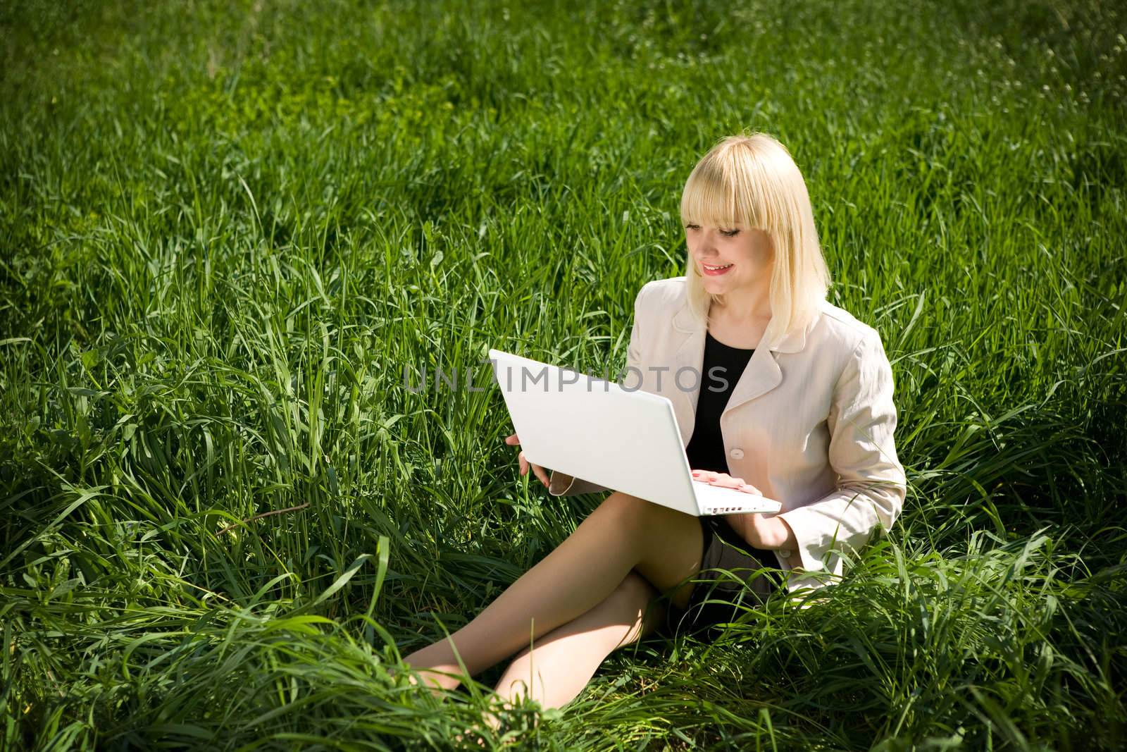 pretty girl with otebook on the grass