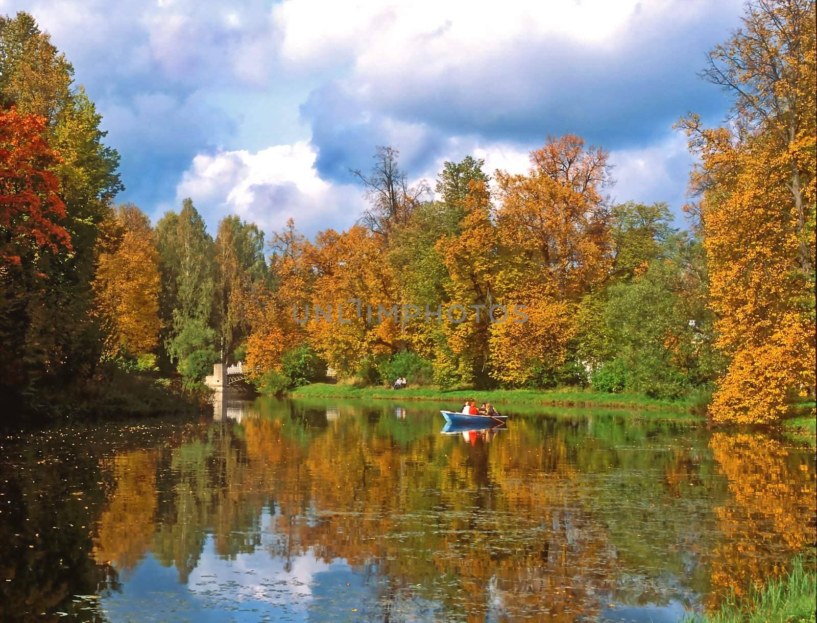 Autumn trees and pond with a boat