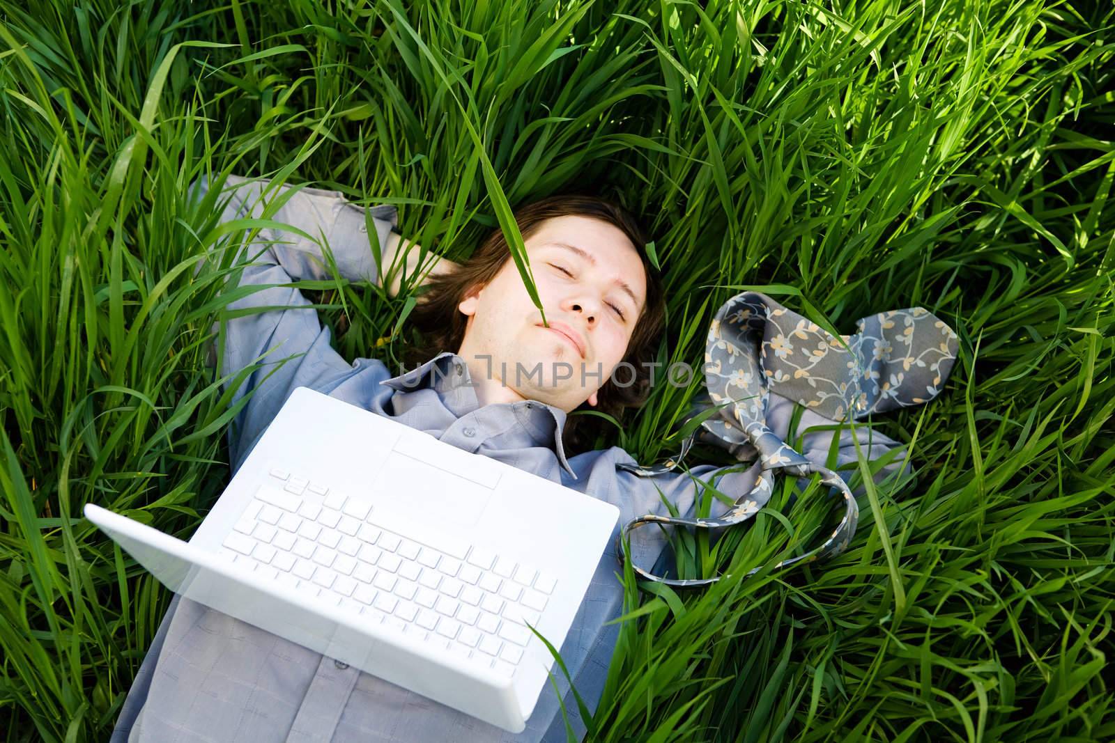 businessman rest on the grass with laptop