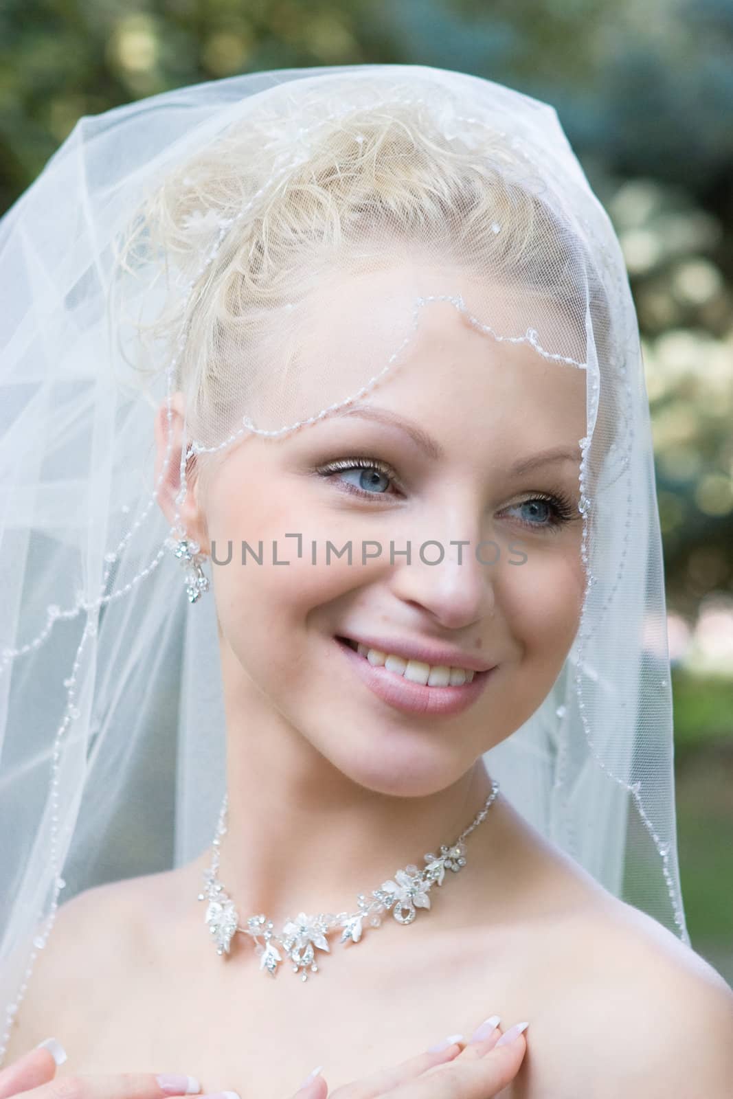 beautiful blond blu-eyes bride laughs in the meadow