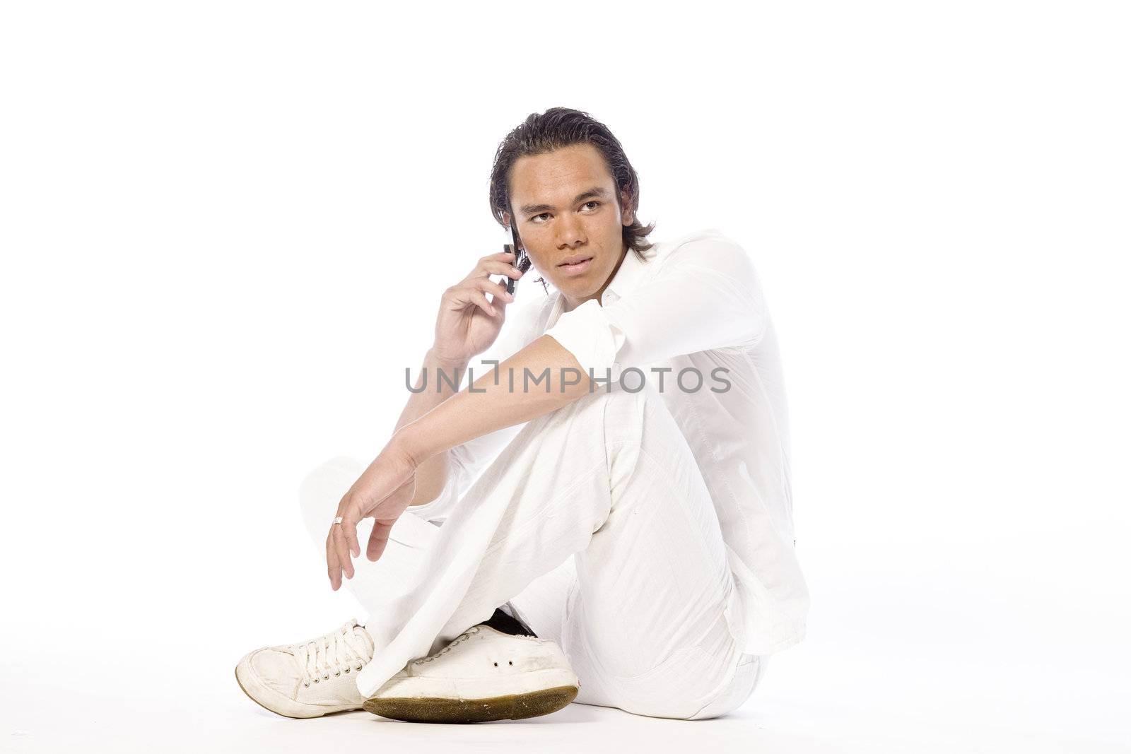 Studio portrait of a muscular Asian sexy looking boy making a call