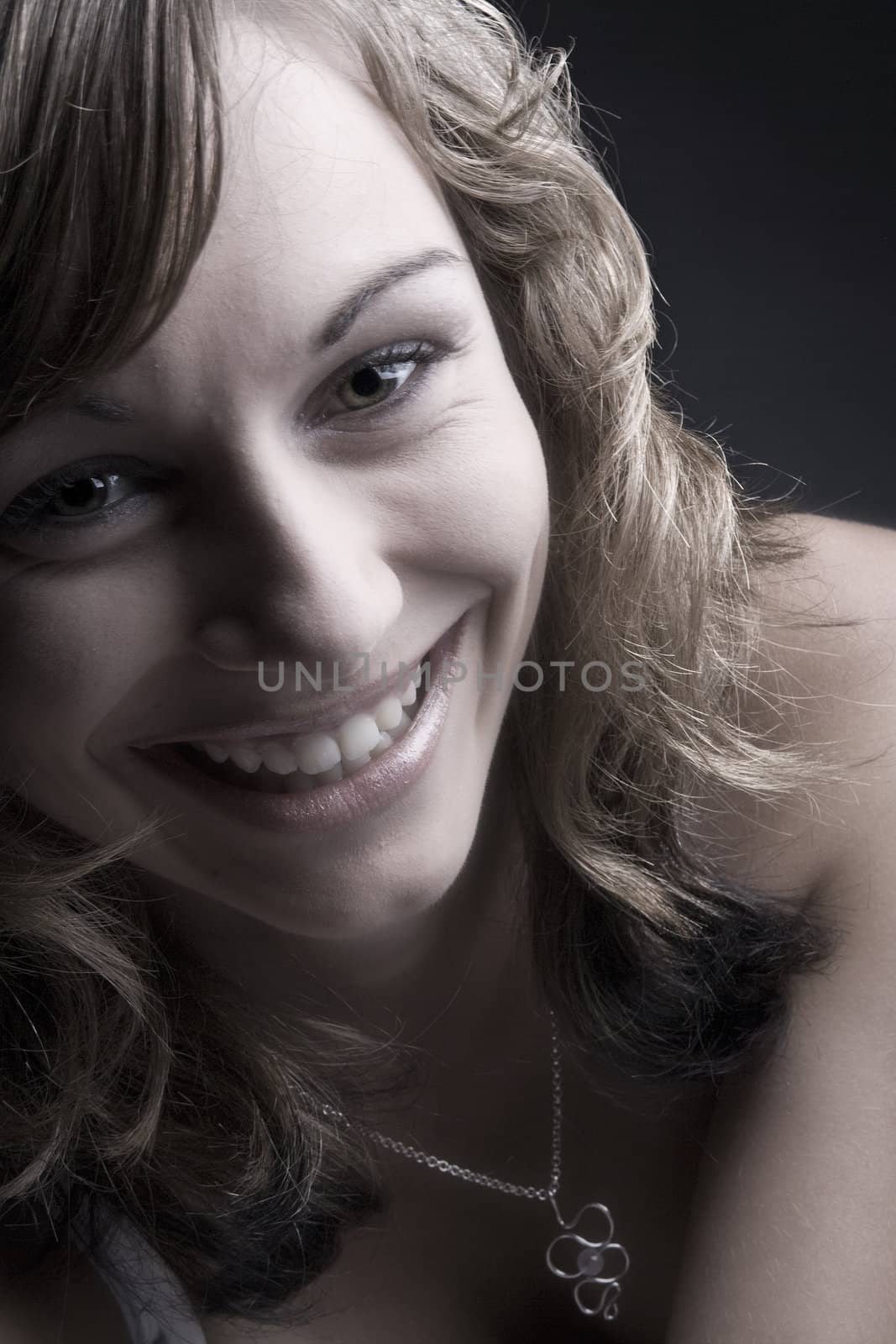 Studio portrait of a teenage model smiling her teeths bare.