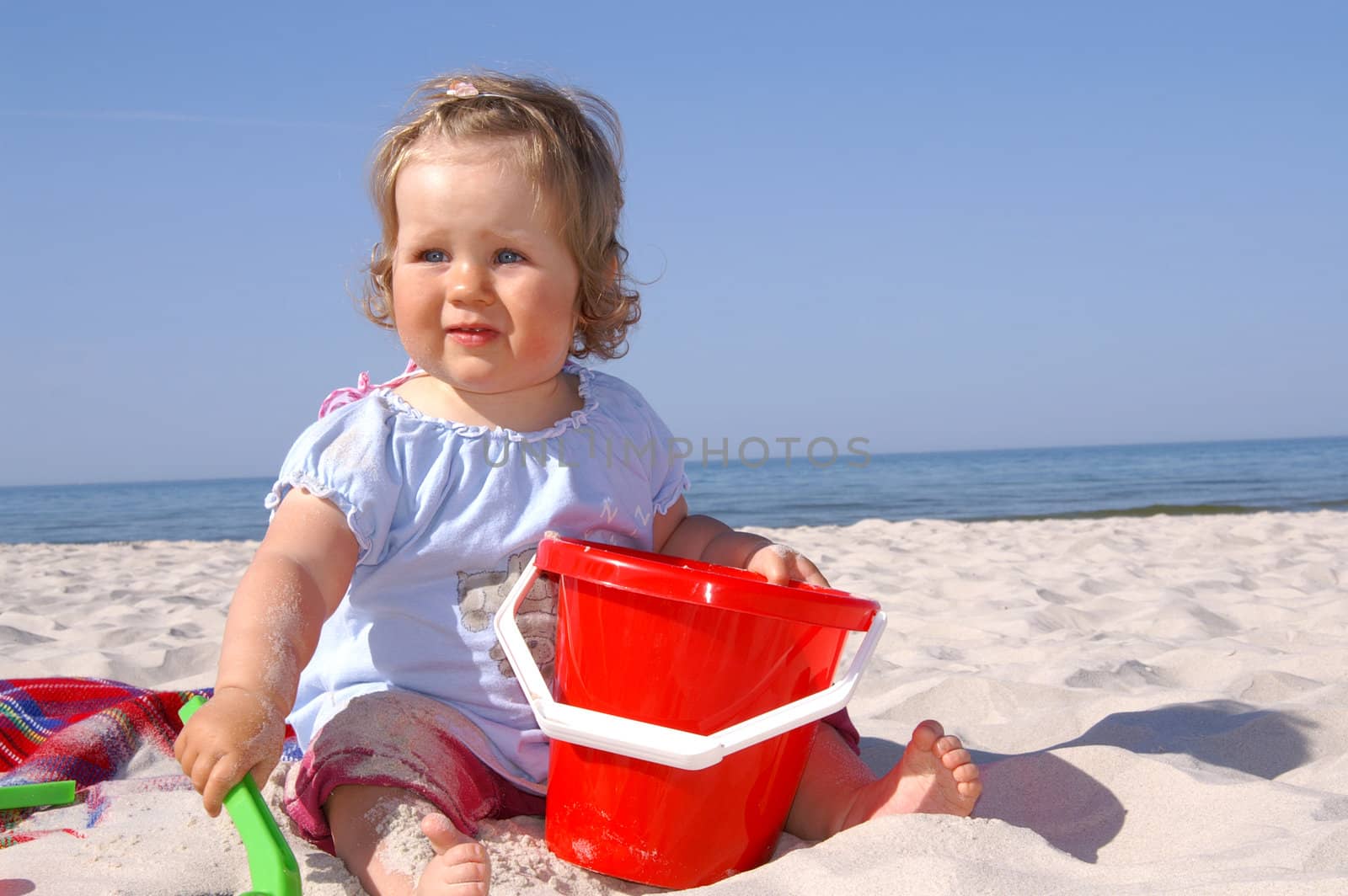 baby girl on the beach and blue sky