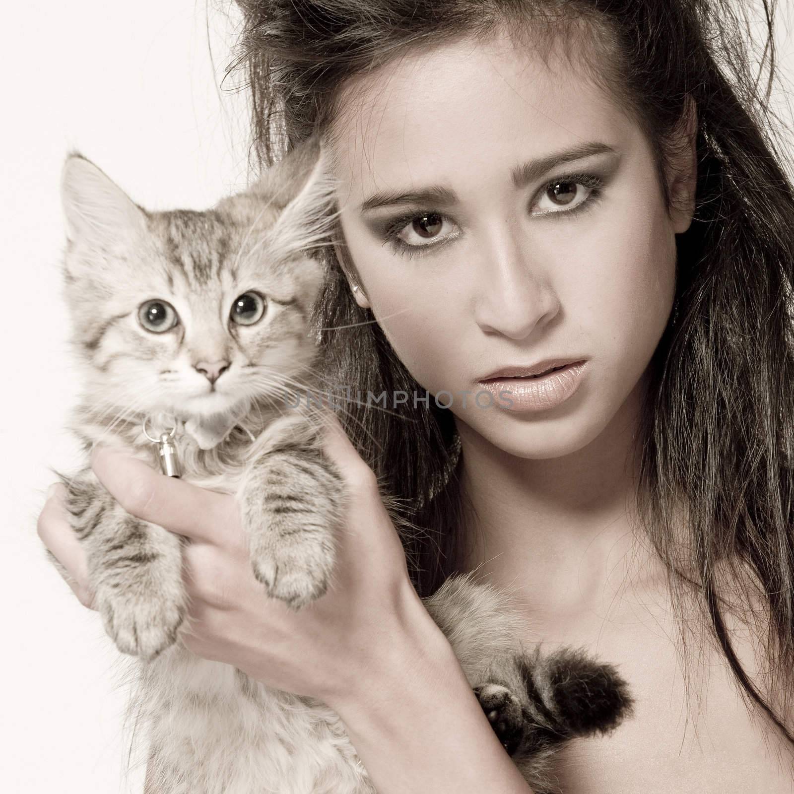 Studio portrait of a beautiful mixed race, vietnamese girl and a main coone kitten