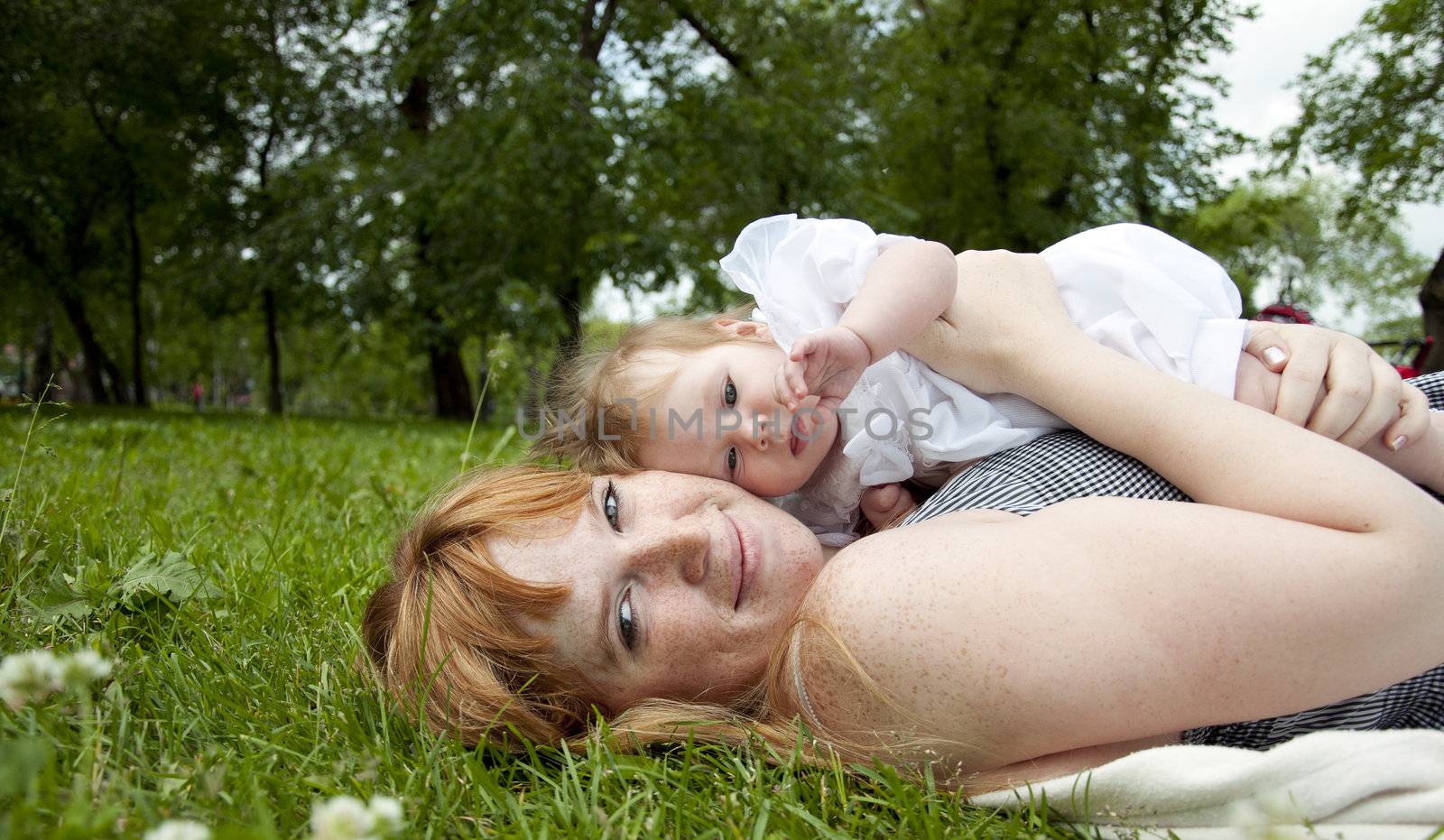 The portrait of the baby and mother on cover in the park