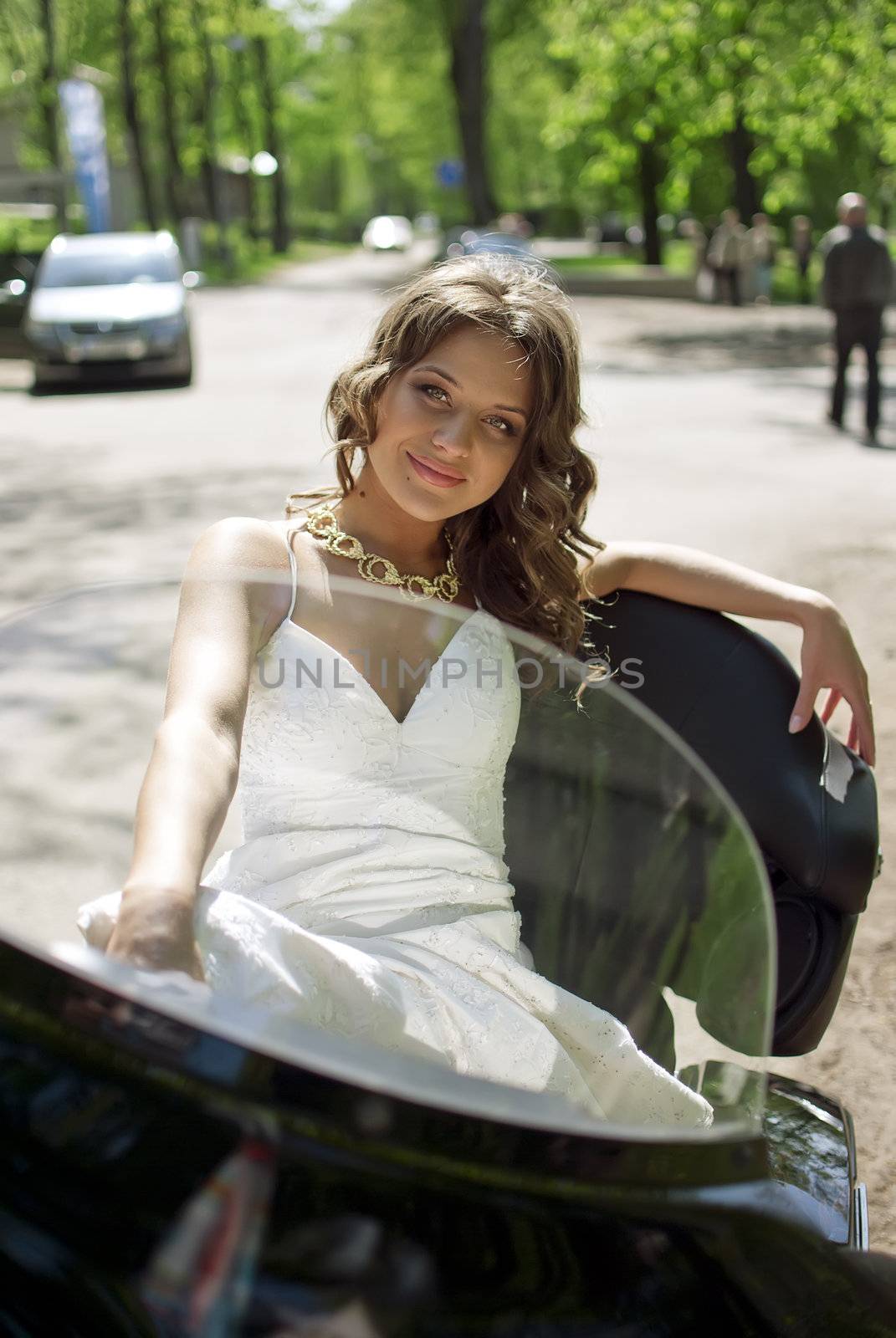 beautiful young bride sitting on a motorcycle