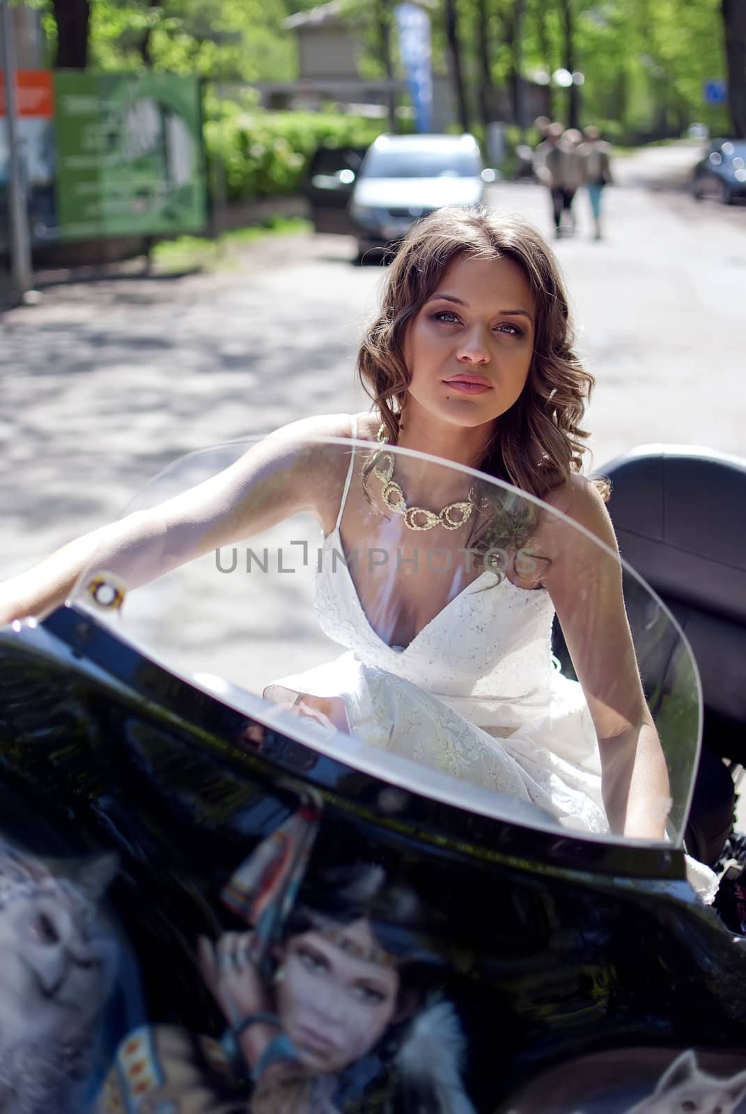 beautiful young bride sitting on a motorcycle