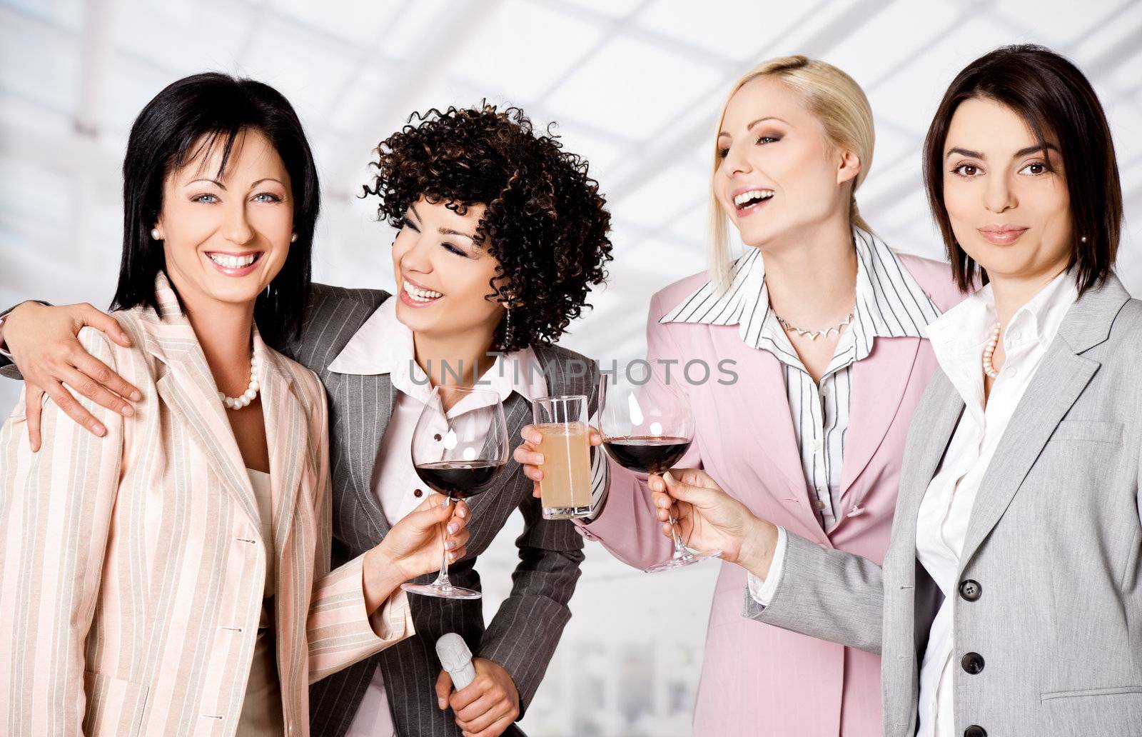 Team of four happy businesswomen smiling and celebrating