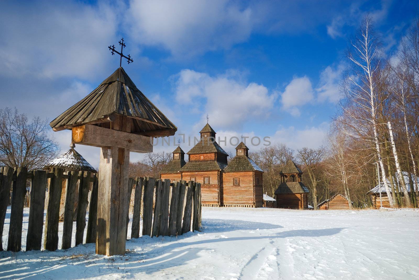 old wooden cross in front of the rural church
