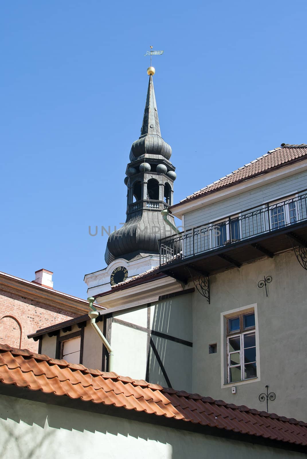 old tower with a weather vane in the city