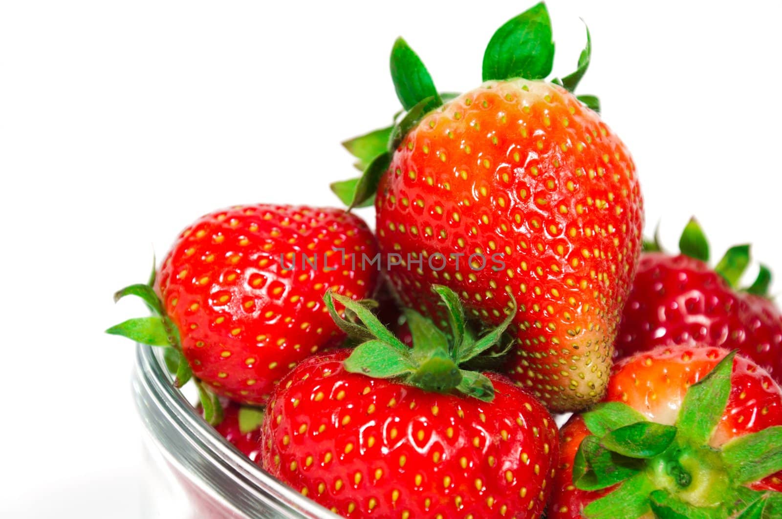 Fresh organic strawberries in a glass bowl, isolated