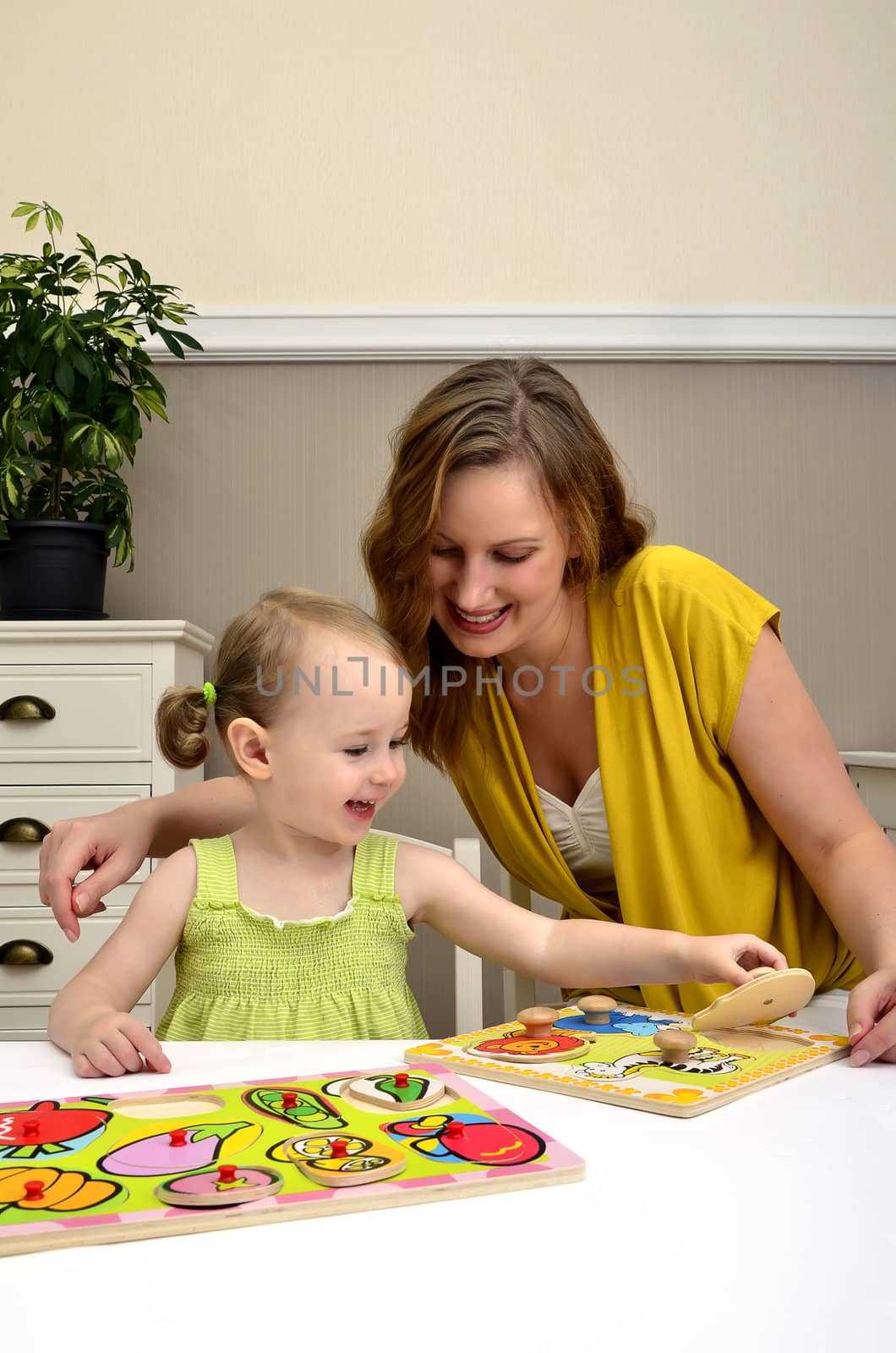 little girl and mom playing in a children puzzle