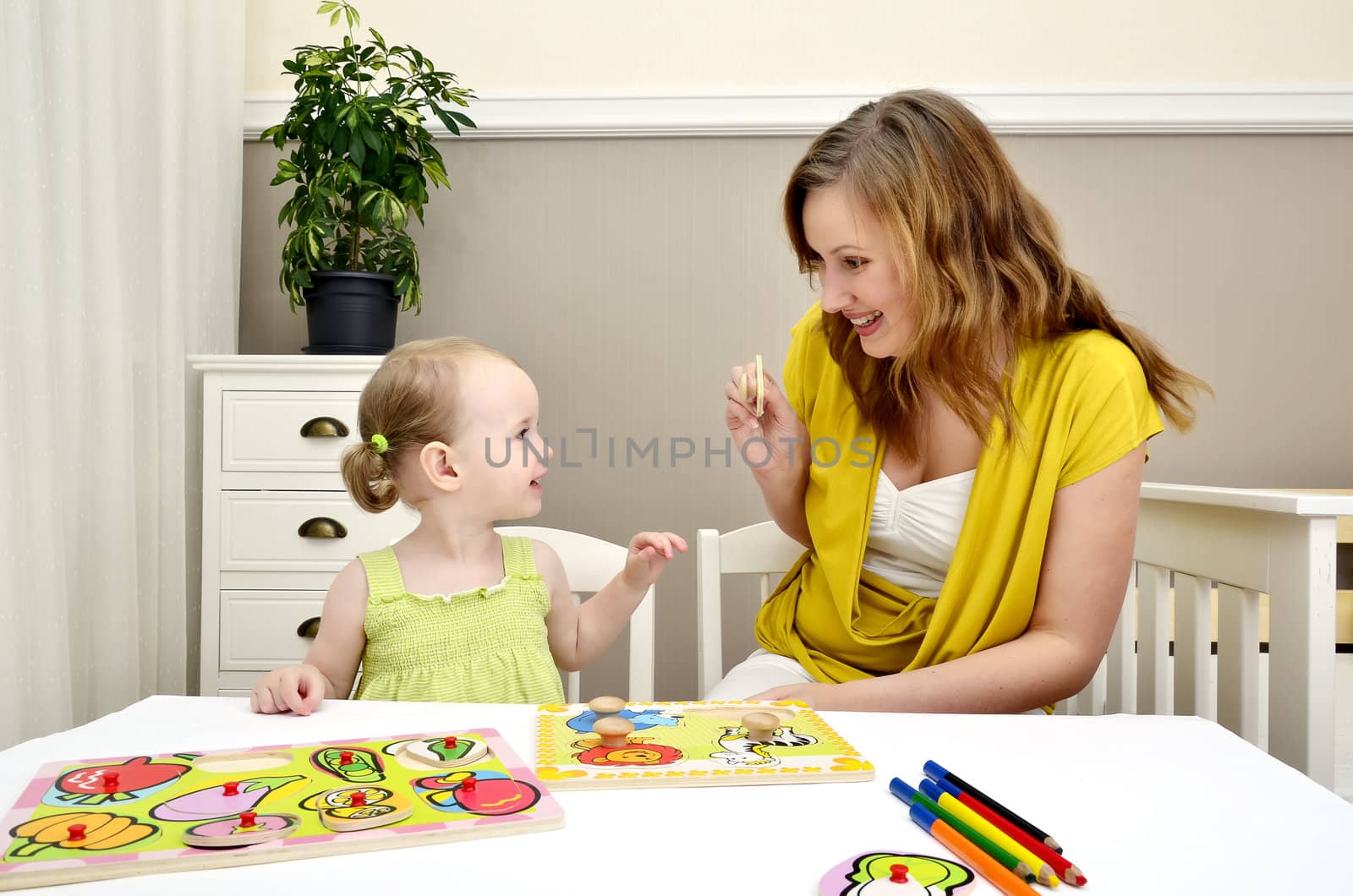 little girl and mom playing in a children puzzle