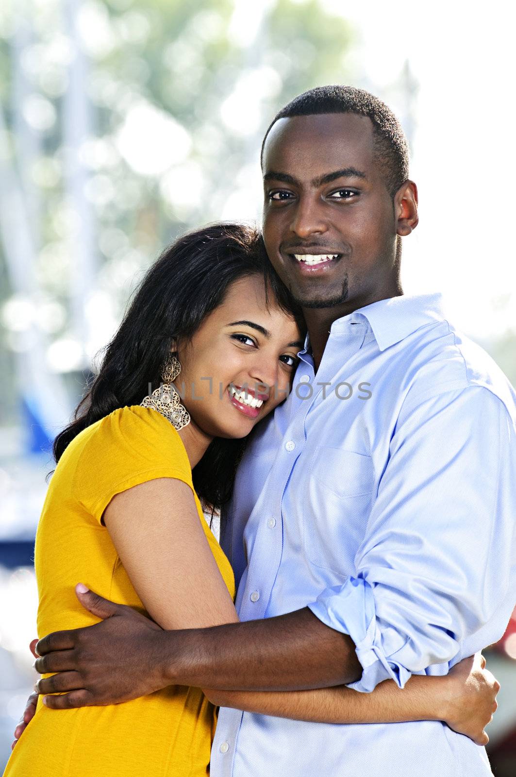 Young romantic couple hugging and standing at harbor