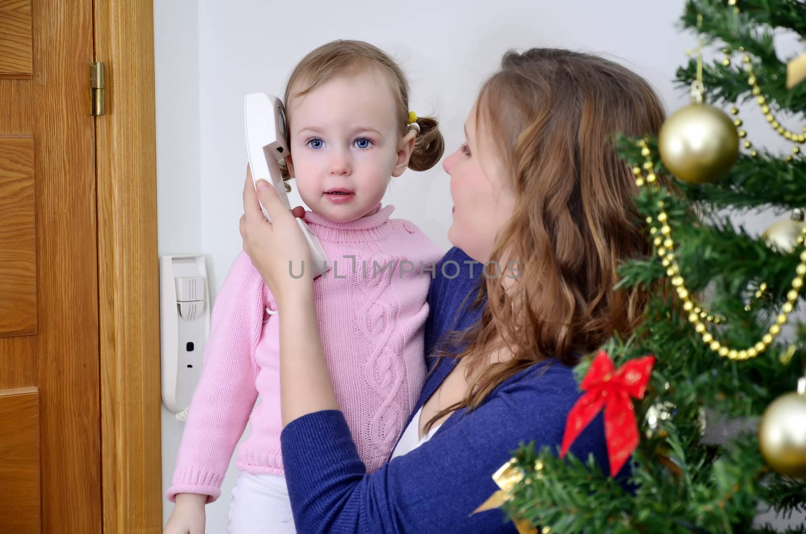 christmas call. mother and child calling by the phone at the christmas