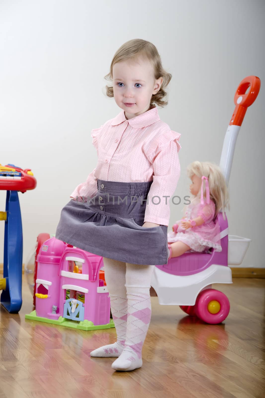 little girl standing in a room with toys