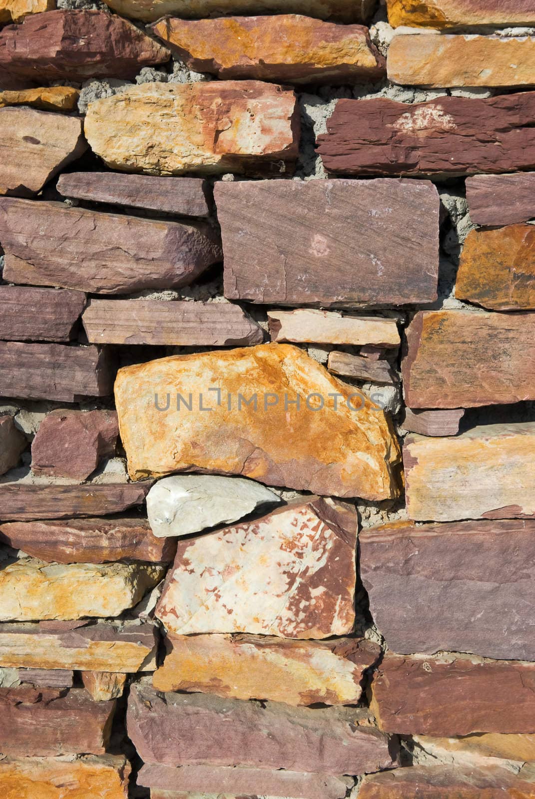 Laid-old wall of granite stones close up
